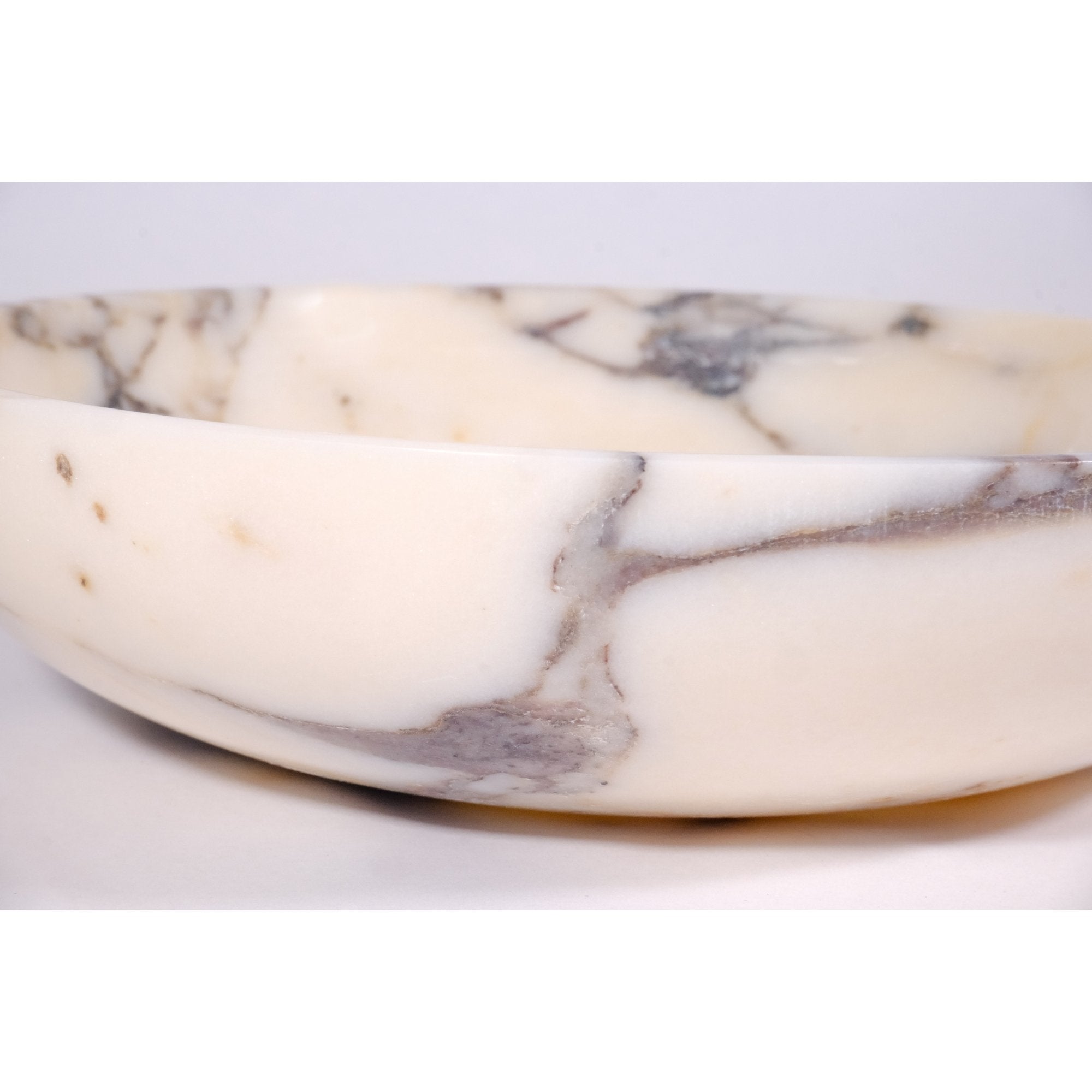 Detailed close-up of Calacatta Viola marble surface showing smooth polish and organic violet veining pattern.