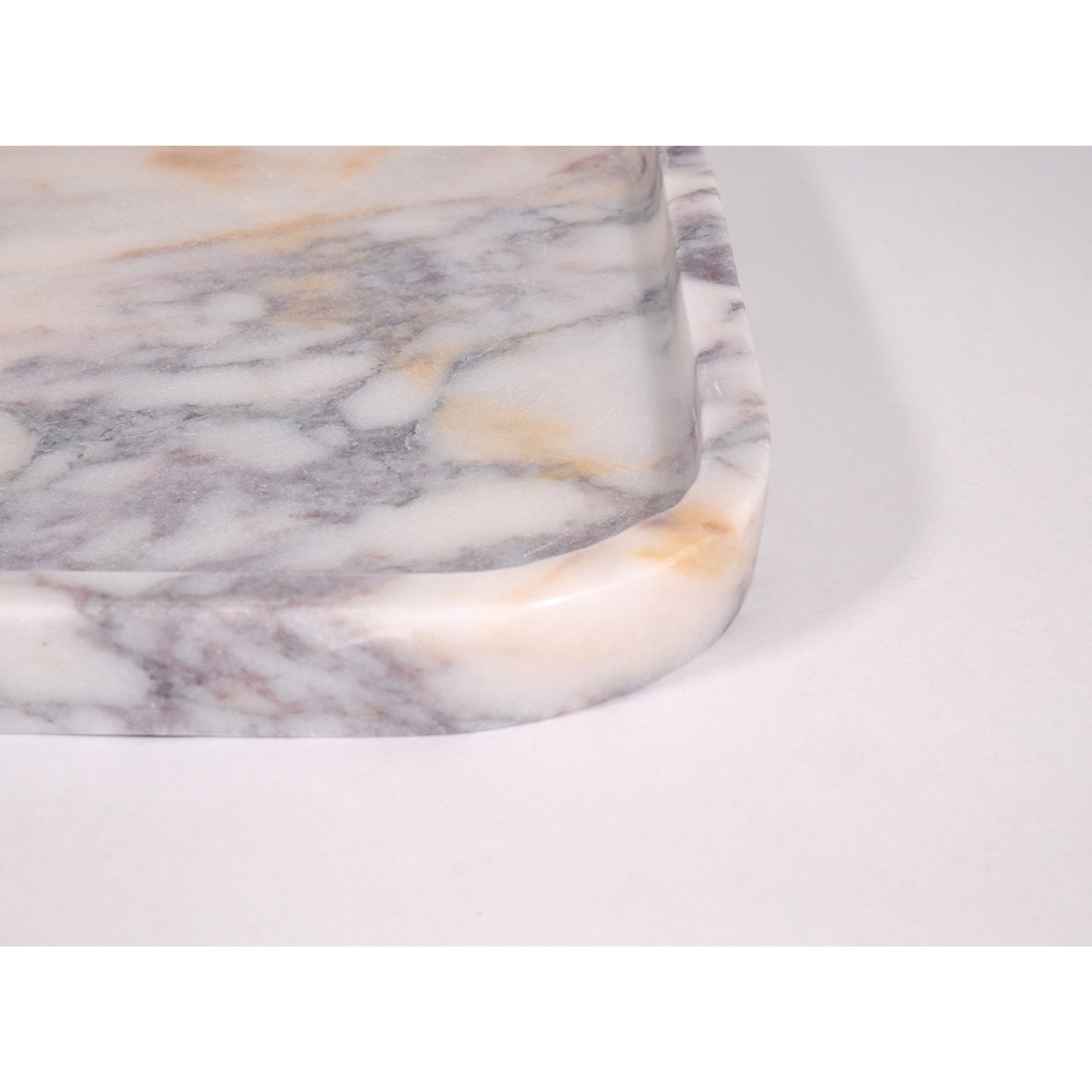 Close-up detail of Calacatta Viola marble tray edge highlighting the honed matte finish and stone texture