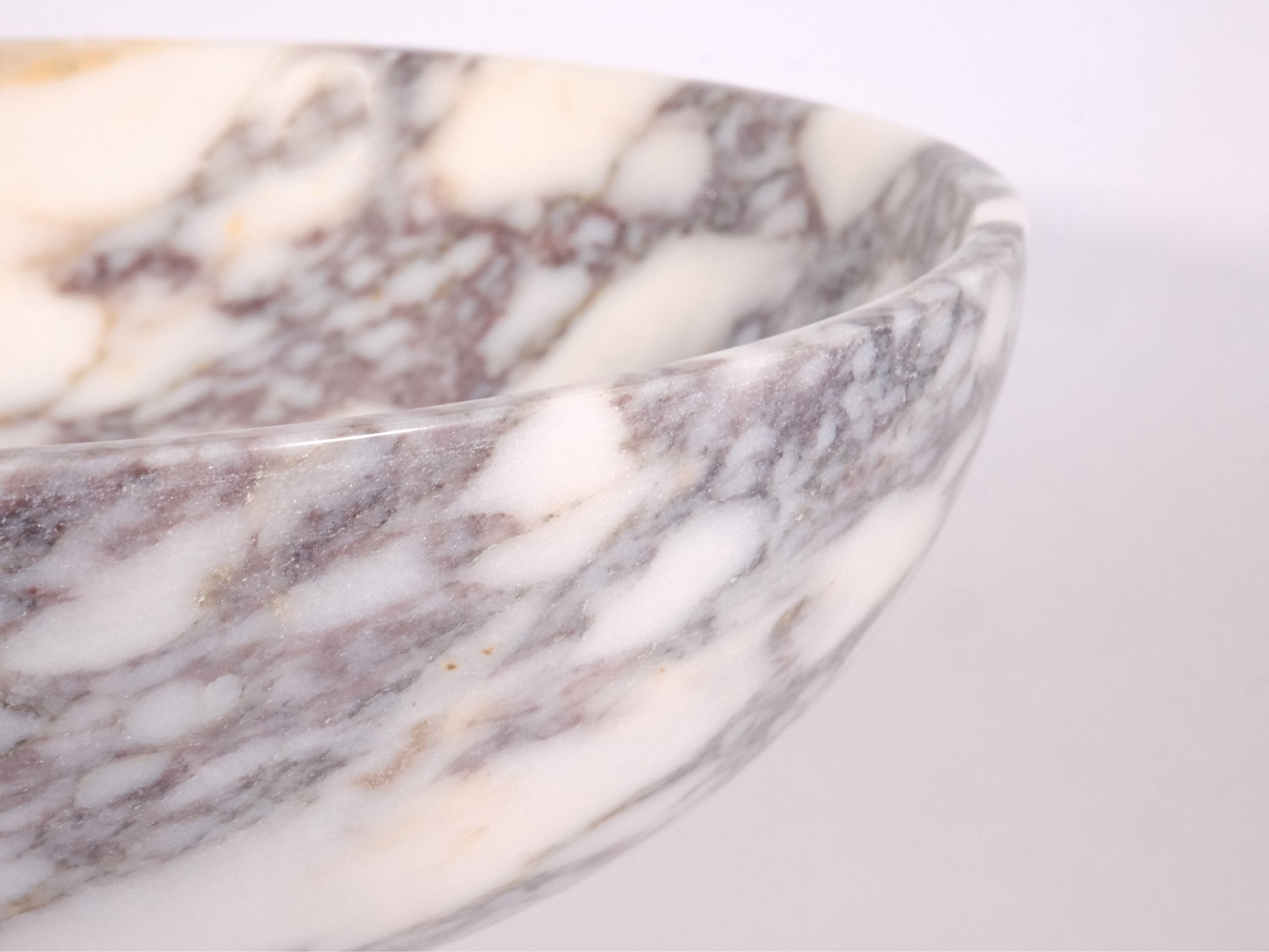 Close-up rim detail of Calacatta Viola marble bowl – polished edge and natural stone texture.
