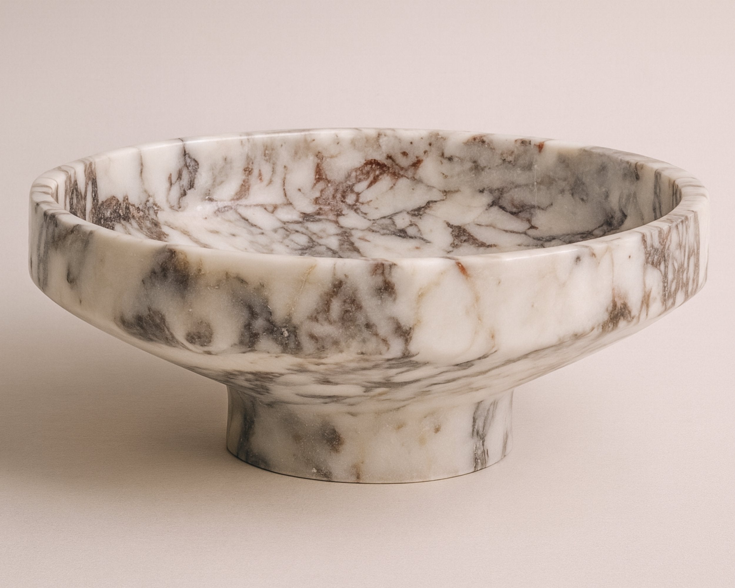 Calacatta Viola marble pedestal bowl, handcrafted centerpiece with natural burgundy veining on ivory marble.