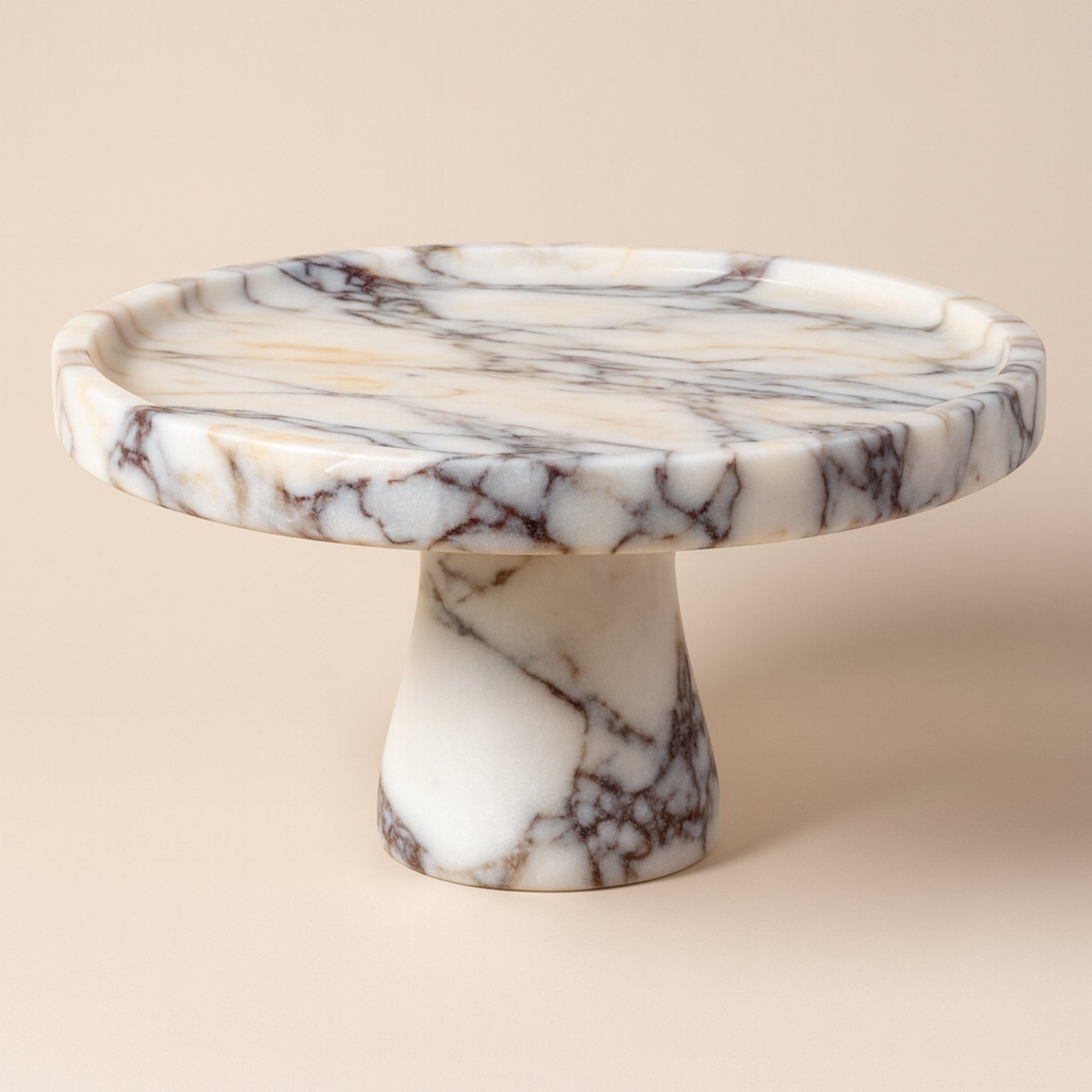 Calacatta Viola marble pedestal serving bowl, luxury cake stand with violet-gold veining on sculptural base, elevated centerpiece design