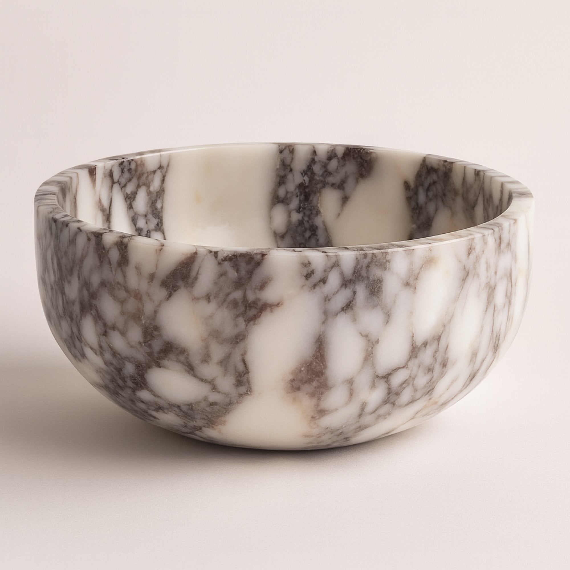 Calacatta Viola marble pedestal bowl on clean white background, showcasing natural veining and polished finish.