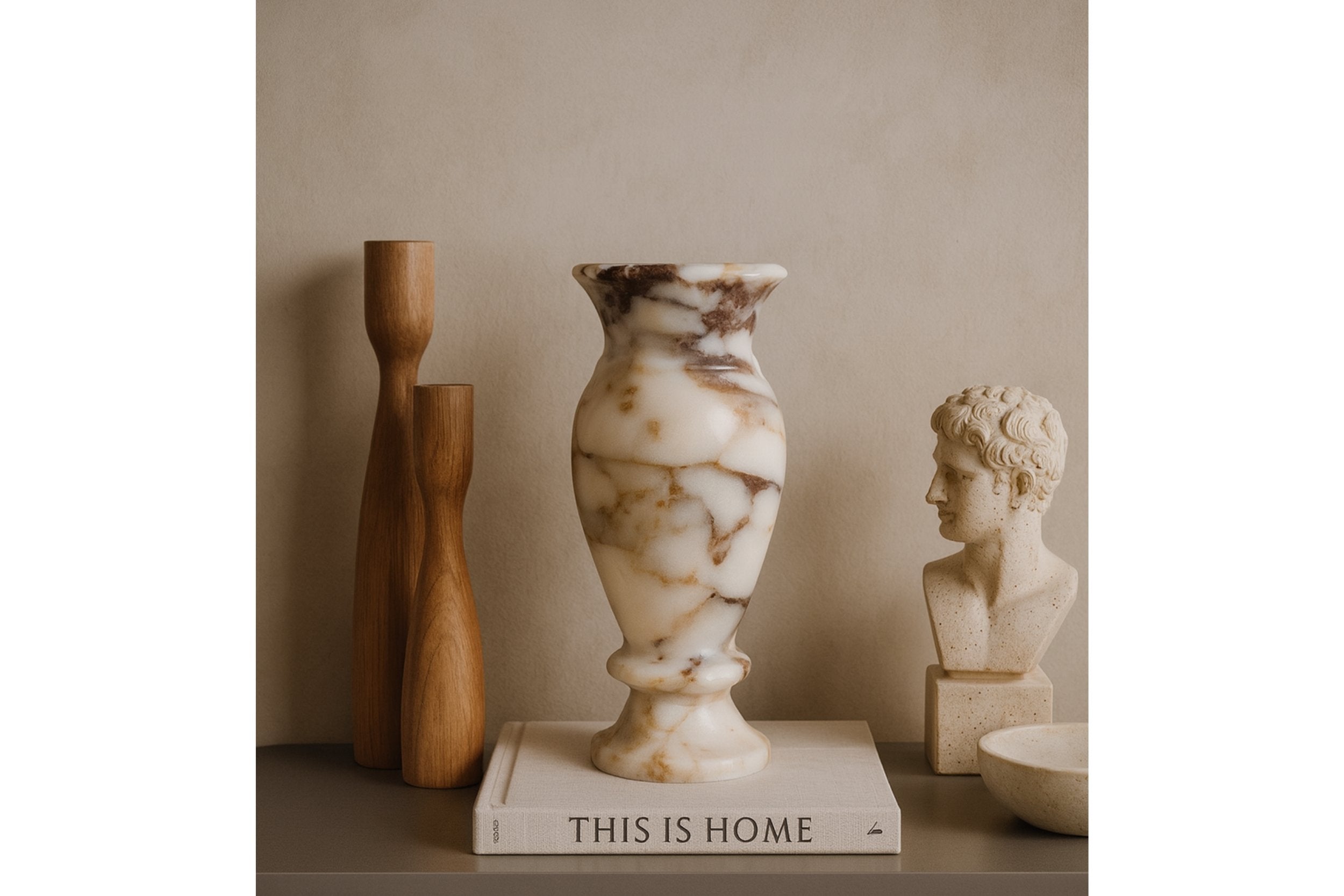 Luxury marble vase placed on design books with modern sculptures – wabi-sabi aesthetic interior