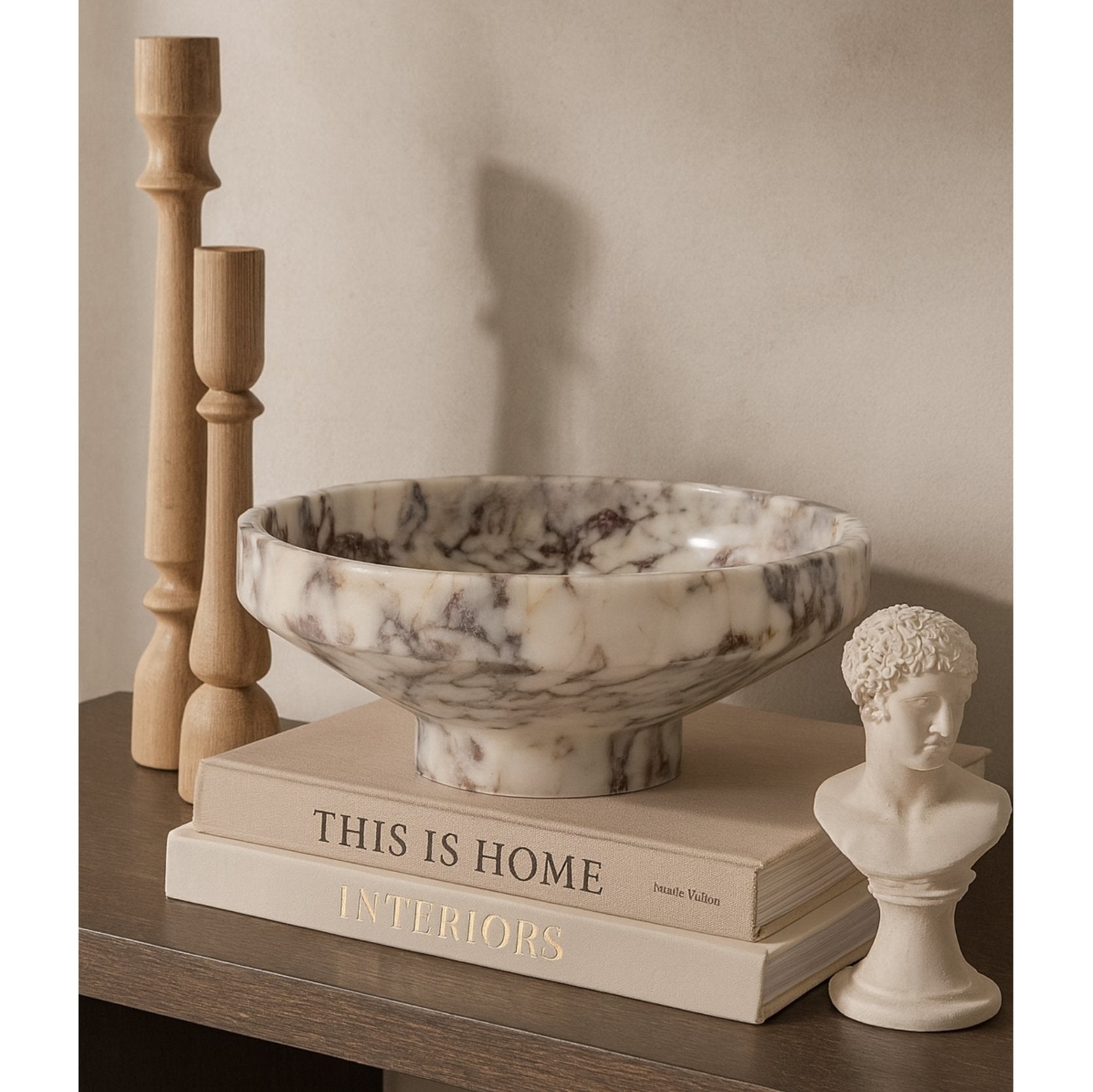 Calacatta Viola marble bowl styled on a neutral stone plinth in soft daylight, modern minimalist interior.