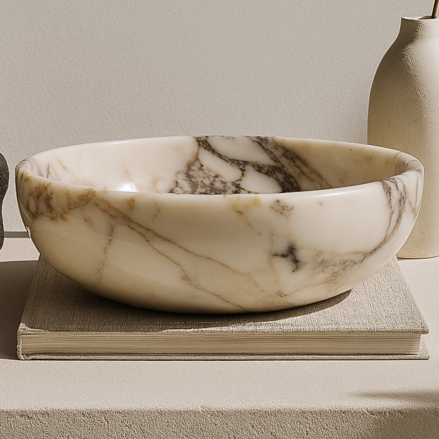 Calacatta Viola marble serving bowl styled on a modern kitchen counter with soft warm lighting, evoking luxury and sophistication.