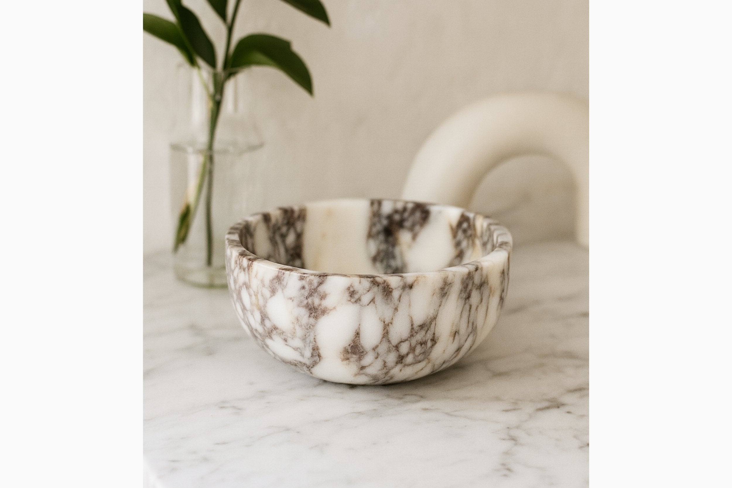 Calacatta Viola marble bowl styled on a linen surface with natural light and minimalist home decor.