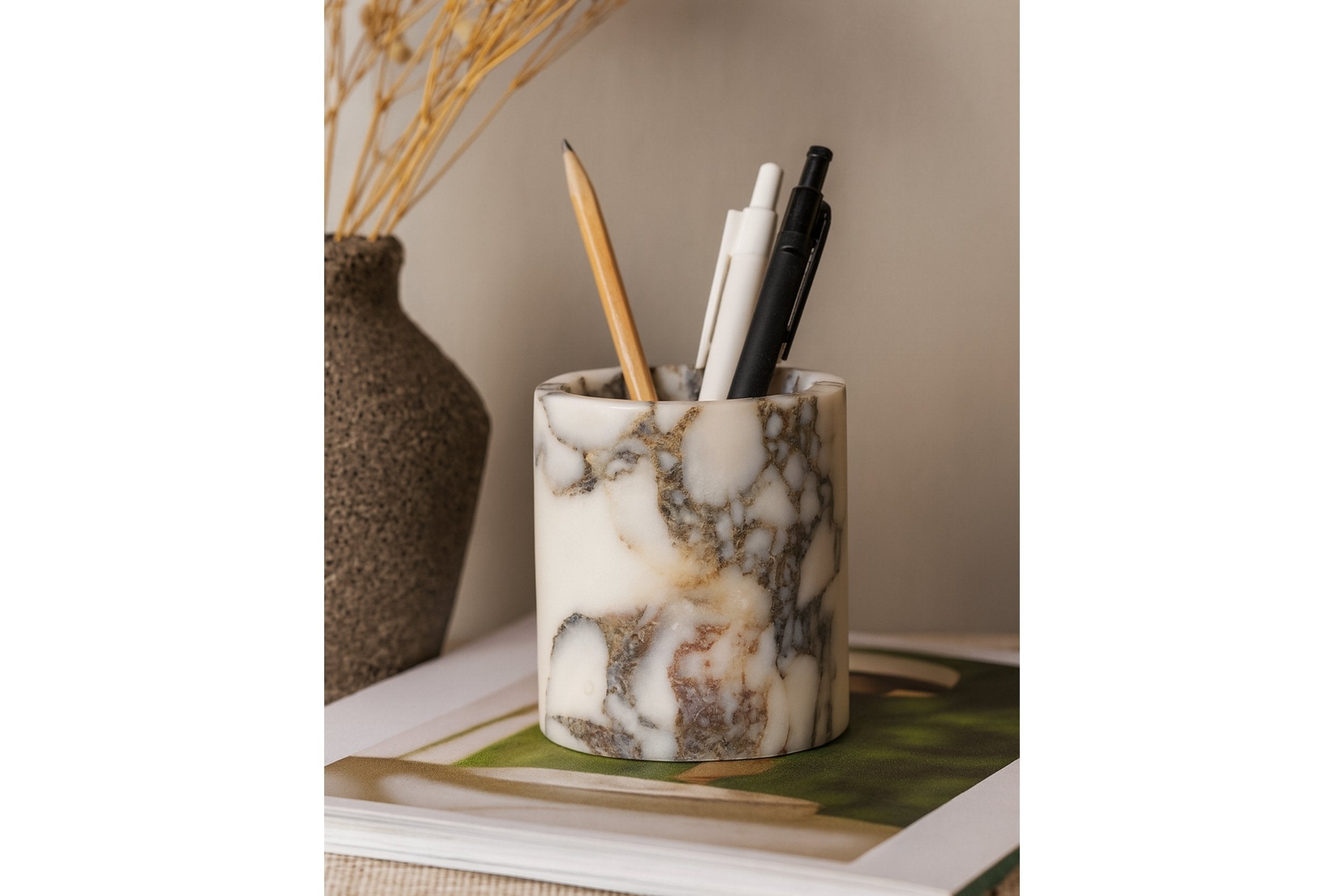 Calacatta Viola marble pen holder styled on a wooden desk with pens – warm lighting, modern rustic workspace aesthetic.