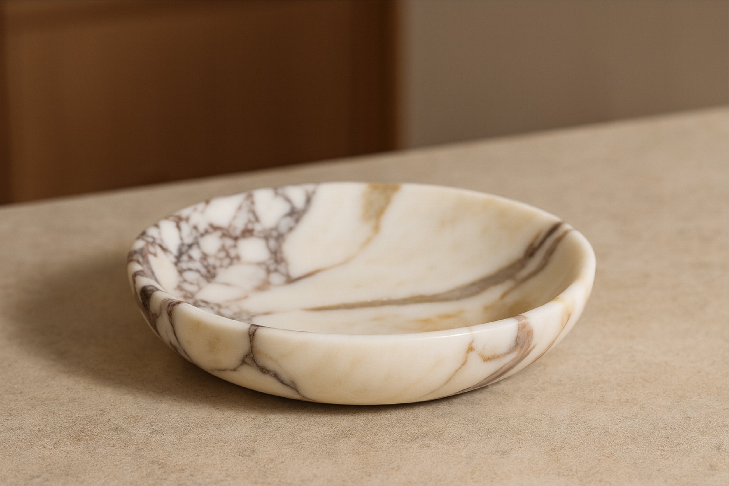 Elegant Calacatta Viola marble plate on a warm-toned surface with natural daylight, capturing the stone’s rich texture and tones.