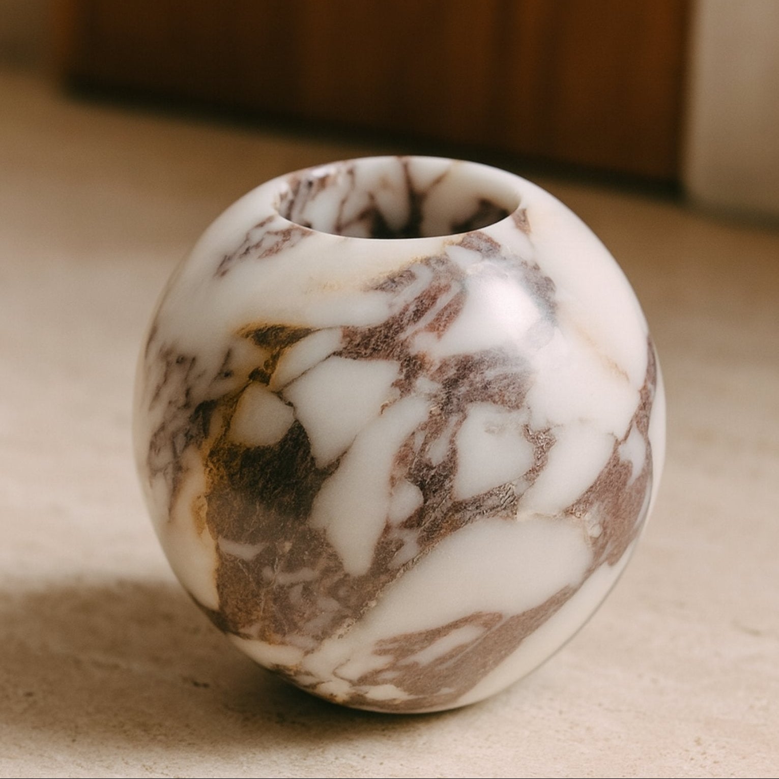 Handcrafted Calacatta Viola marble vase displayed in natural light on a neutral stone surface — minimalist and timeless decor accent.