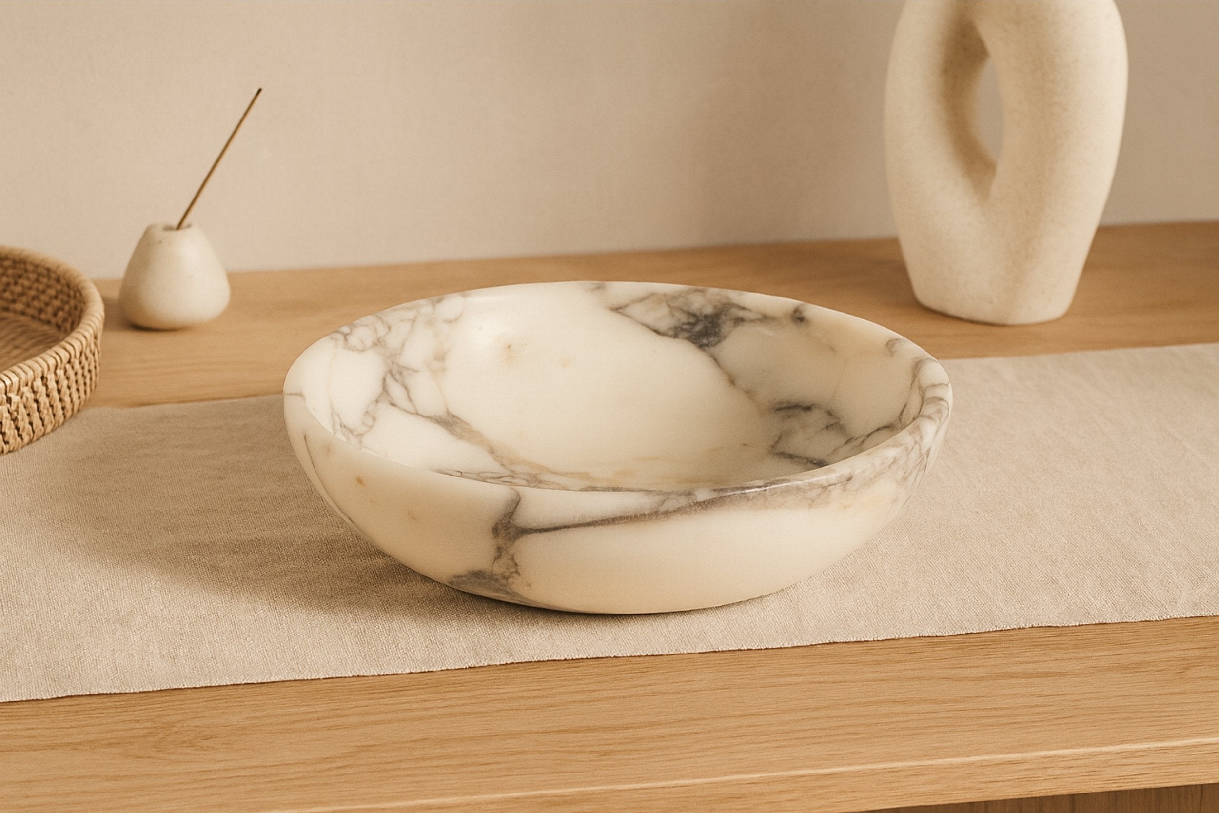 Calacatta Viola marble bowl styled with minimal decor on linen surface, modern quiet luxury home aesthetic.
