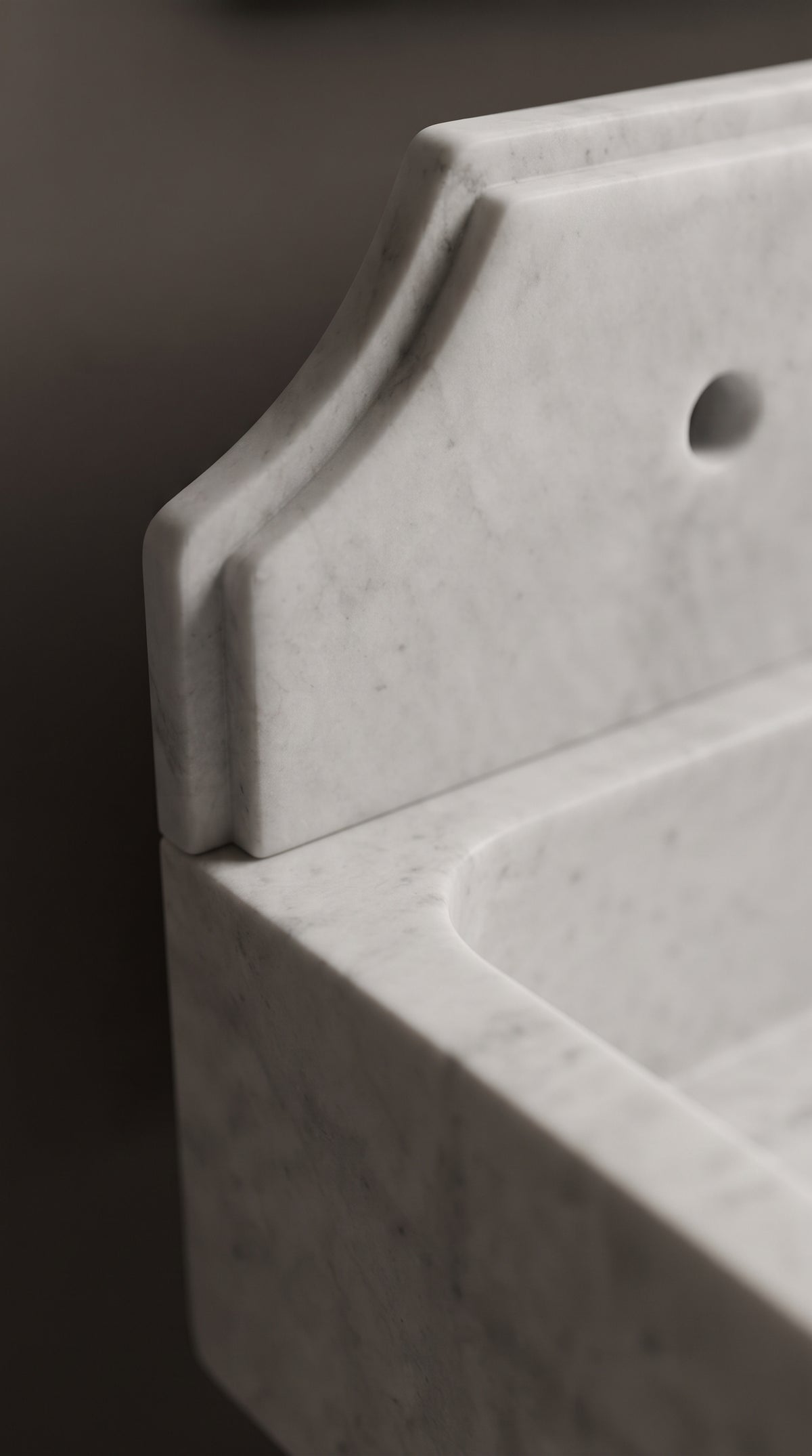 Close-up of the curved marble backsplash and basin rim, showing the hand finished edges and natural Muğla White marble texture.