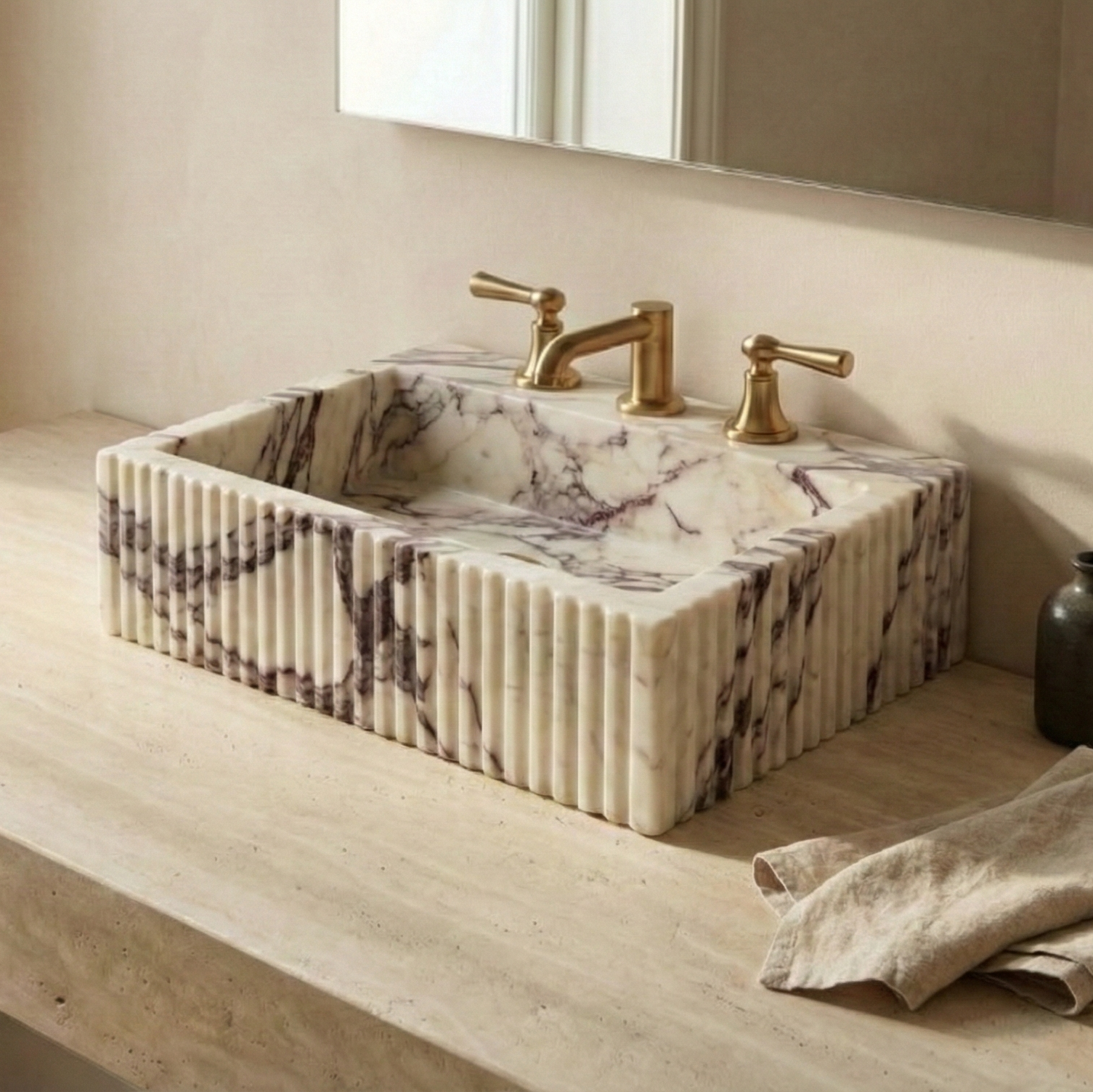 Luxury bathroom scene featuring fluted marble vessel sink with warm natural lighting