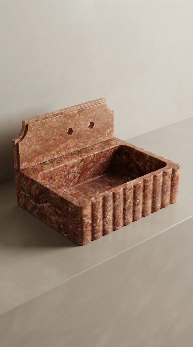 Sculptural profile view of Red Travertine sink highlighting the fluted front and natural stone character