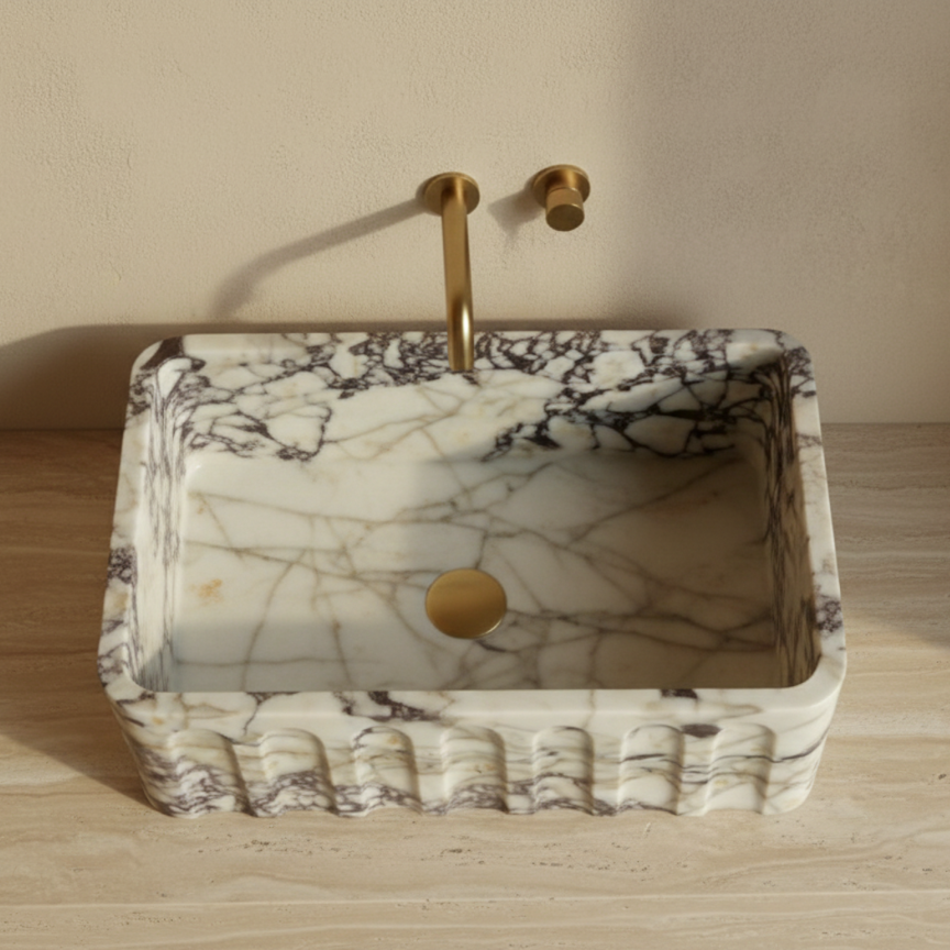 Top view of fluted Calacatta Viola marble rectangular vessel sink with natural veining
