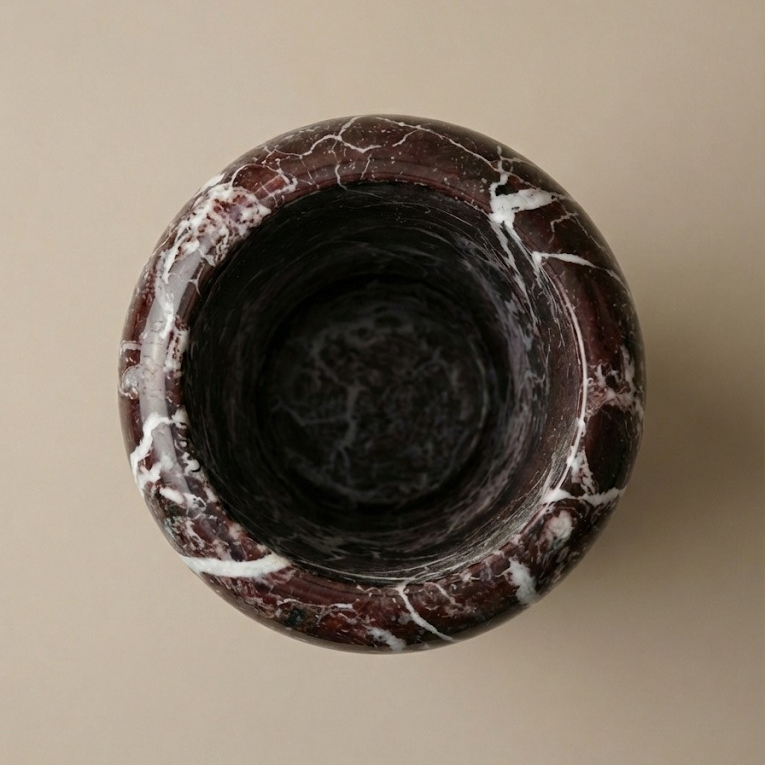 Top view Rosso Levanto marble vase showing circular opening and stone texture