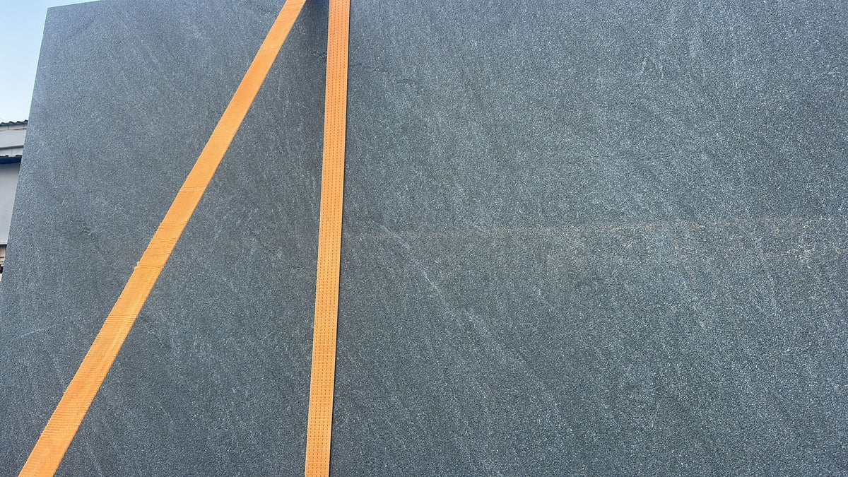 Real Pietra di Cardoso Grigio porcelain slab during handling before fabrication into a round tabletop