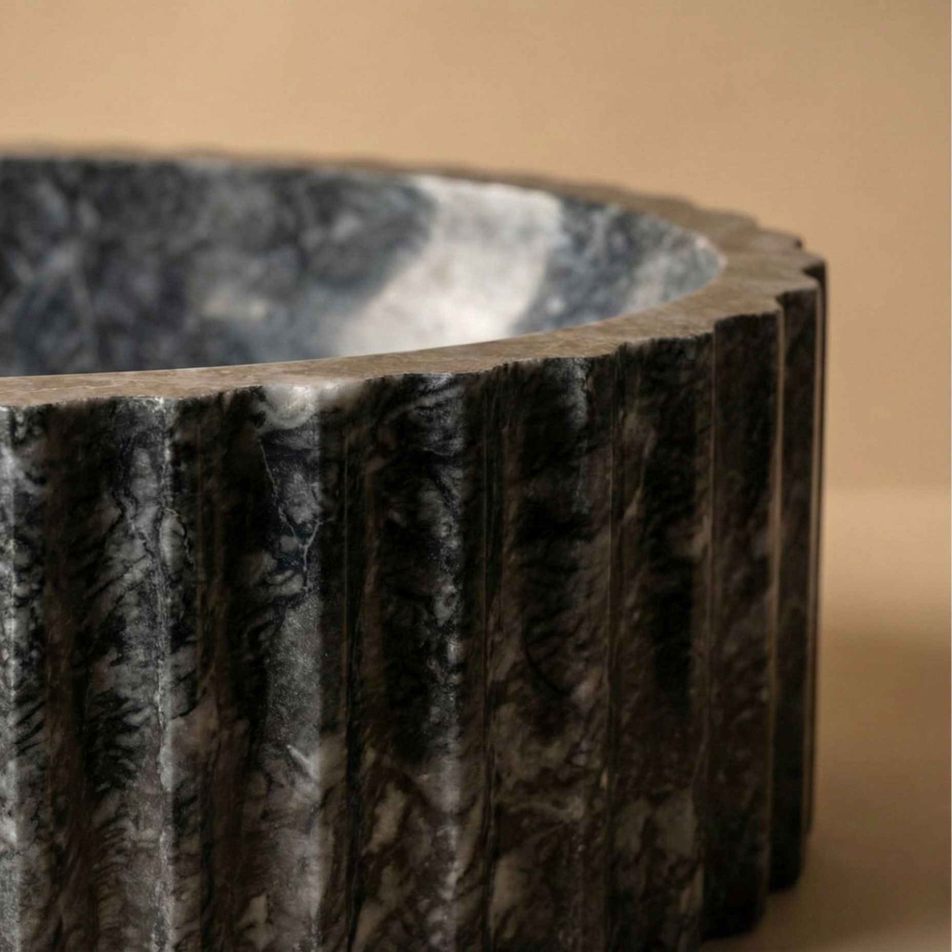 Close up fluted marble texture dark grey oval vessel sink handcrafted stone