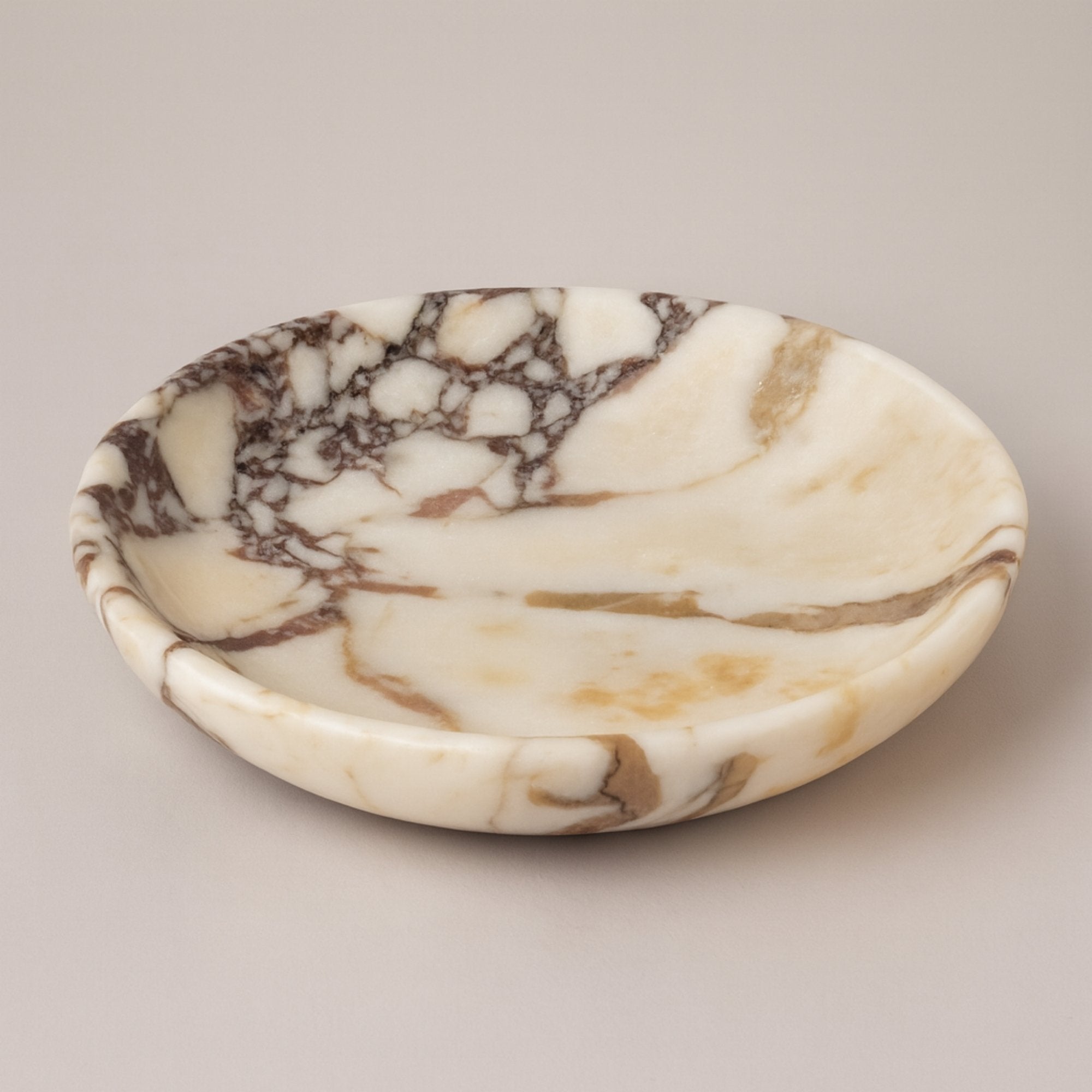 Calacatta Viola marble plate displayed on neutral background, showcasing elegant veining and handcrafted design by Petra Vera.