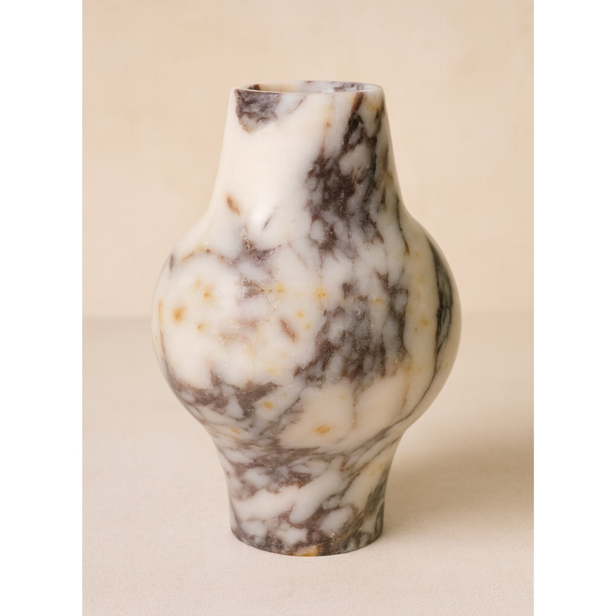 Modern Calacatta Viola marble decorative vase standing on neutral background, showcasing natural violet veining and sculptural form.