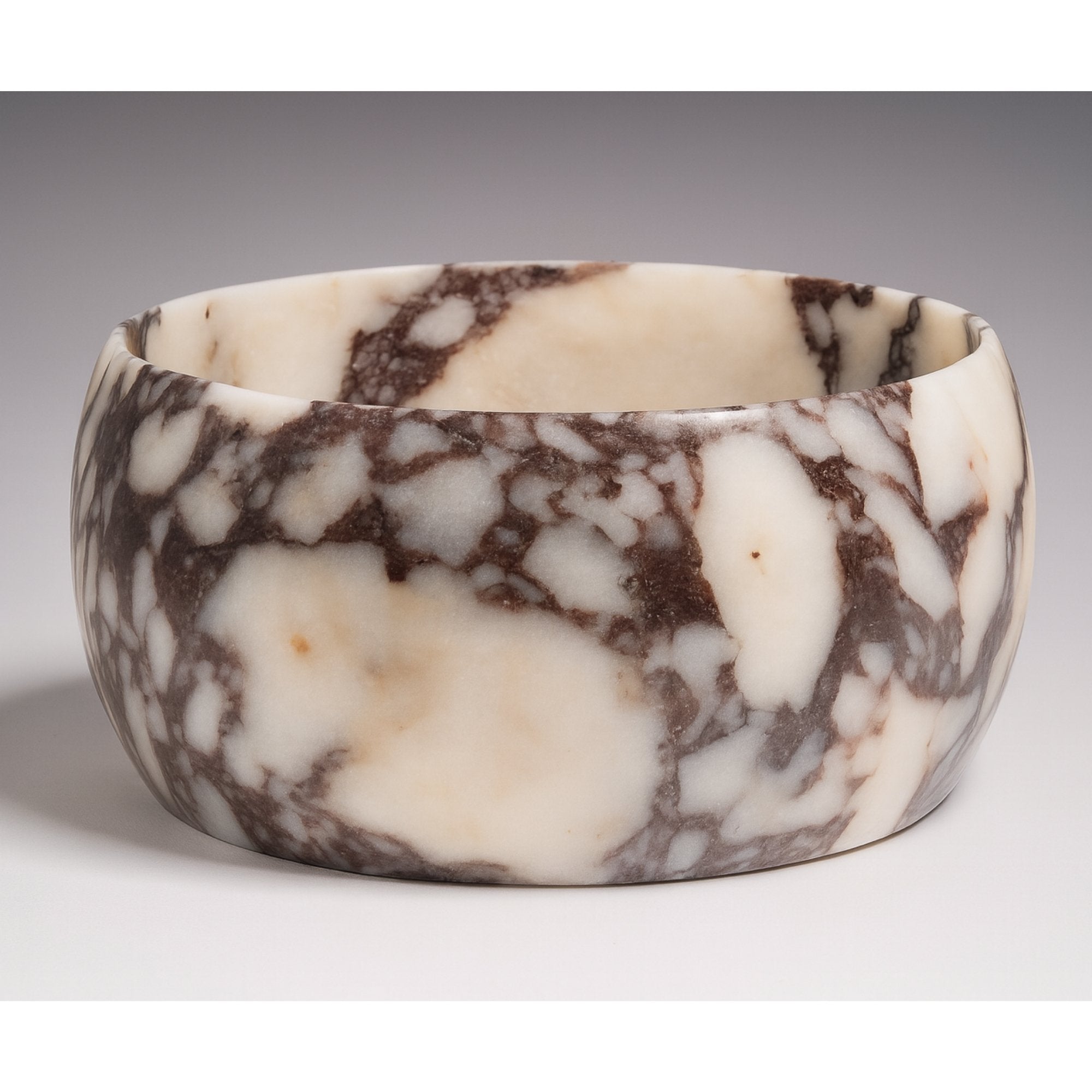 Calacatta Viola marble pedestal decorative bowl, hero view, creamy base with deep viola veining.