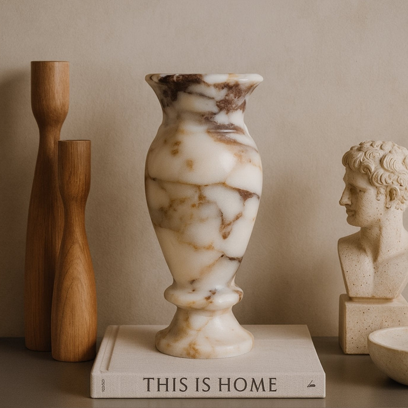 Luxury marble vase placed on design books with modern sculptures – wabi-sabi aesthetic interior