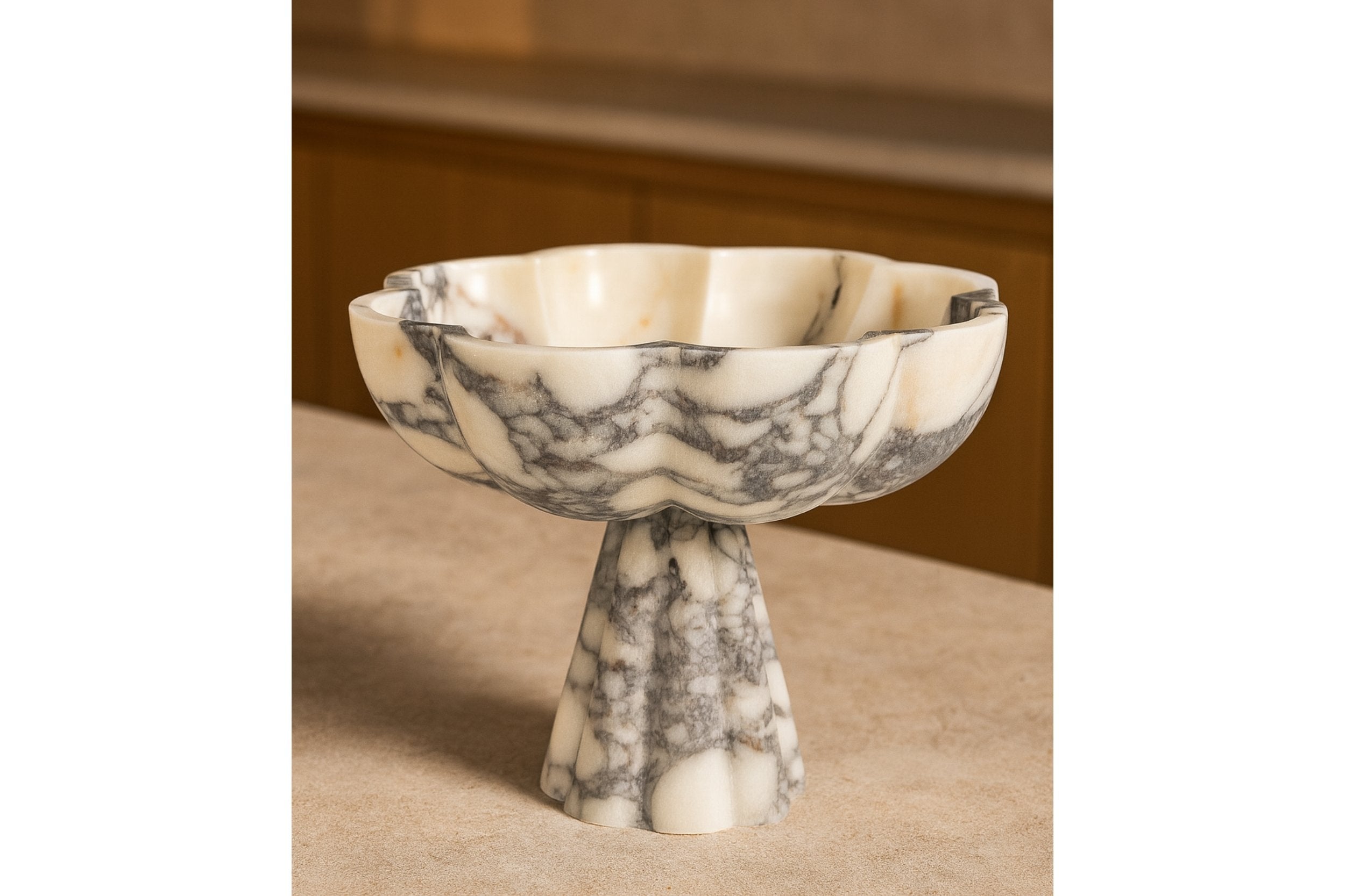 Hand-carved marble pedestal bowl on wooden tabletop, cozy home scene