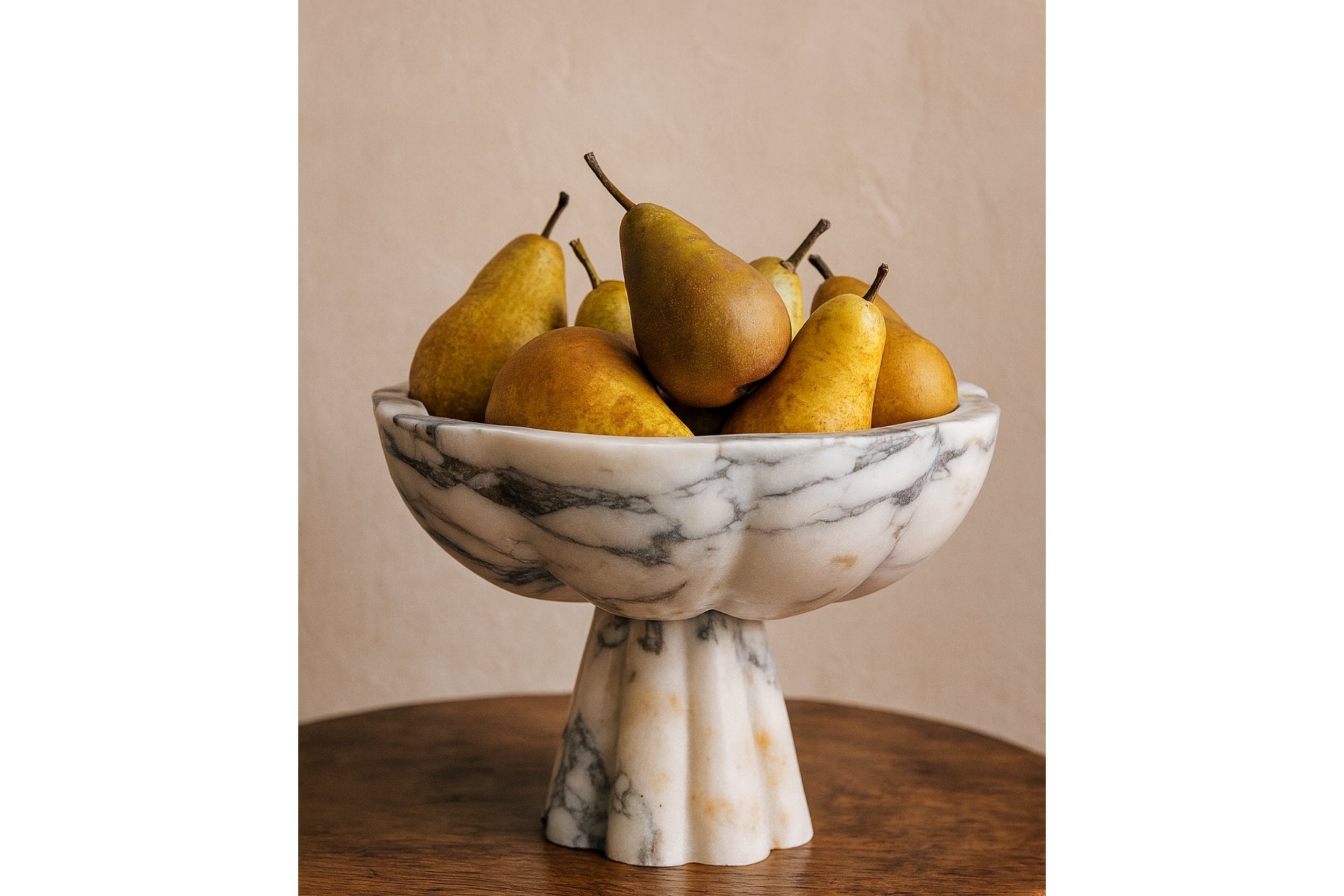 Calacatta Viola marble pedestal bowl styled with pears on wooden table — Petra Vera