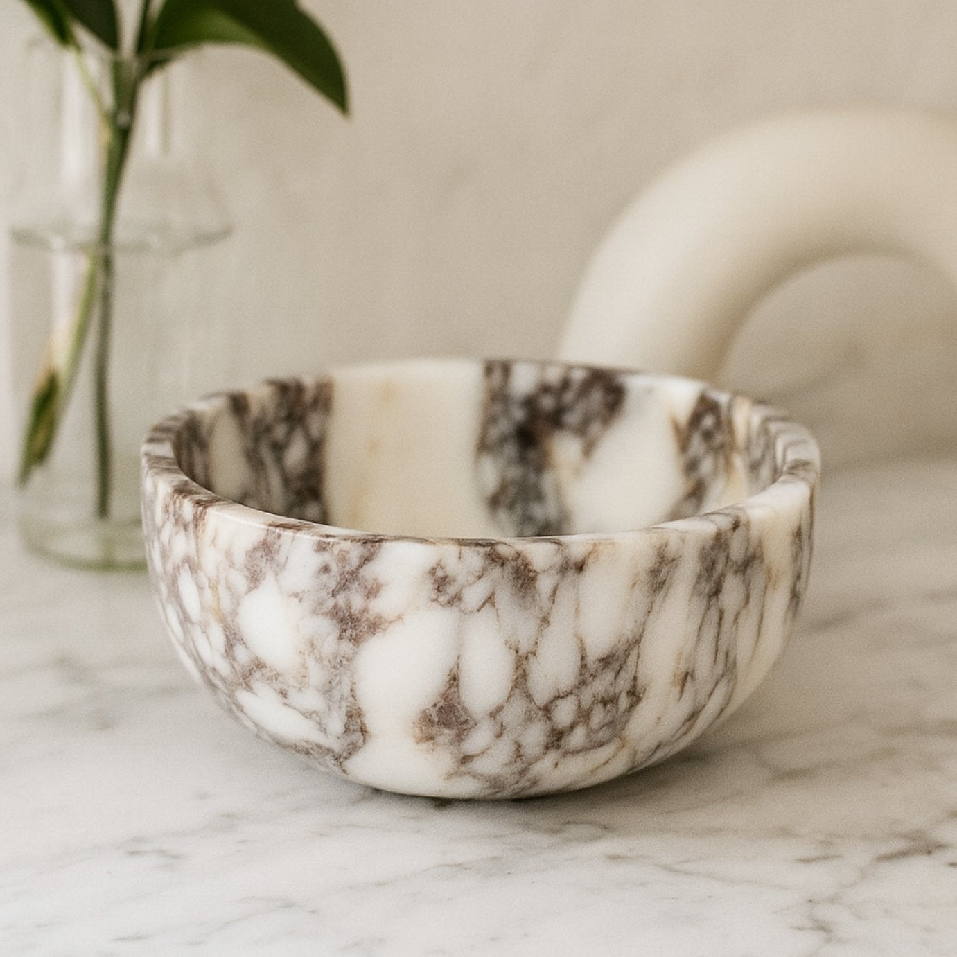 Calacatta Viola marble bowl styled on a linen surface with natural light and minimalist home decor.