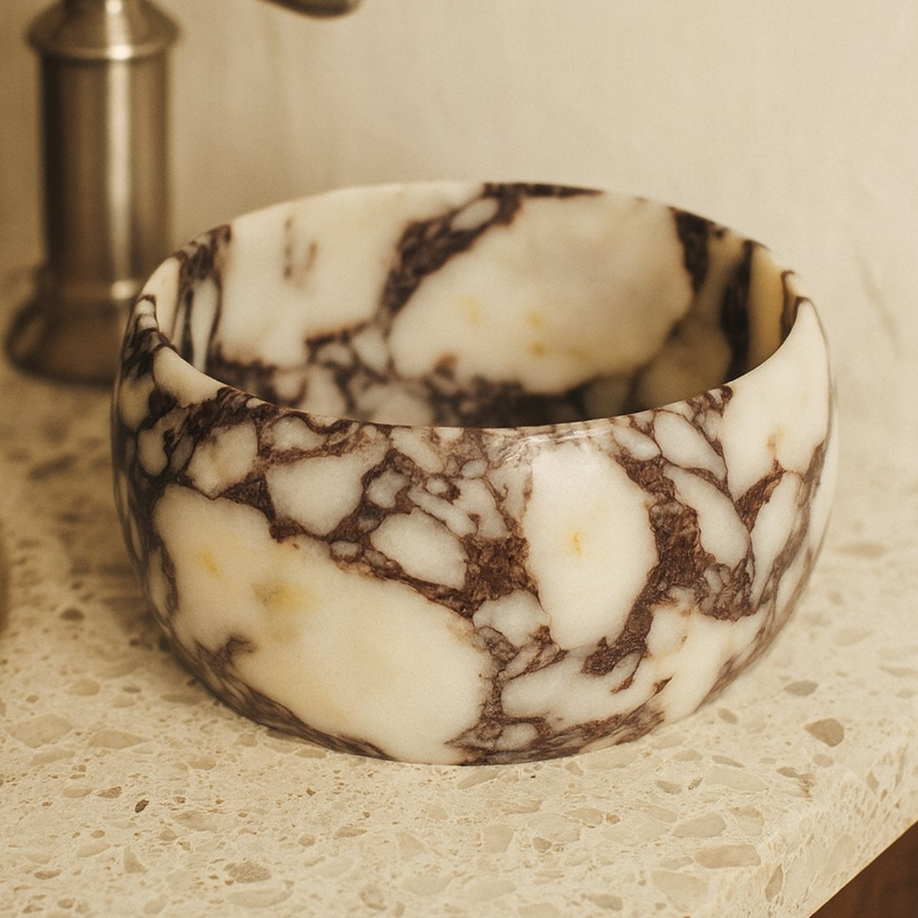 Marble pedestal bowl styled on neutral console, minimalist gallery home décor.