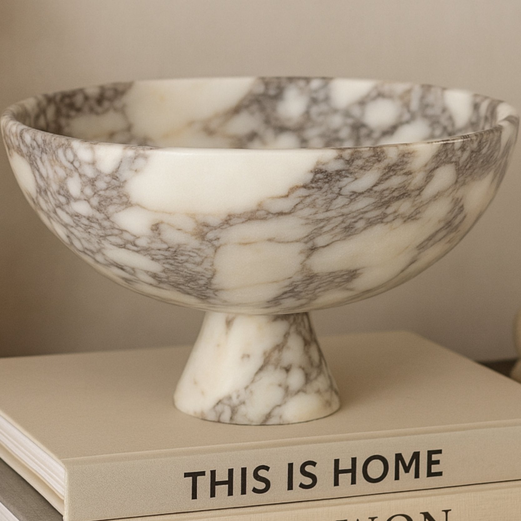 Luxury interior styling featuring a handmade Calacatta Viola marble bowl as decorative centerpiece