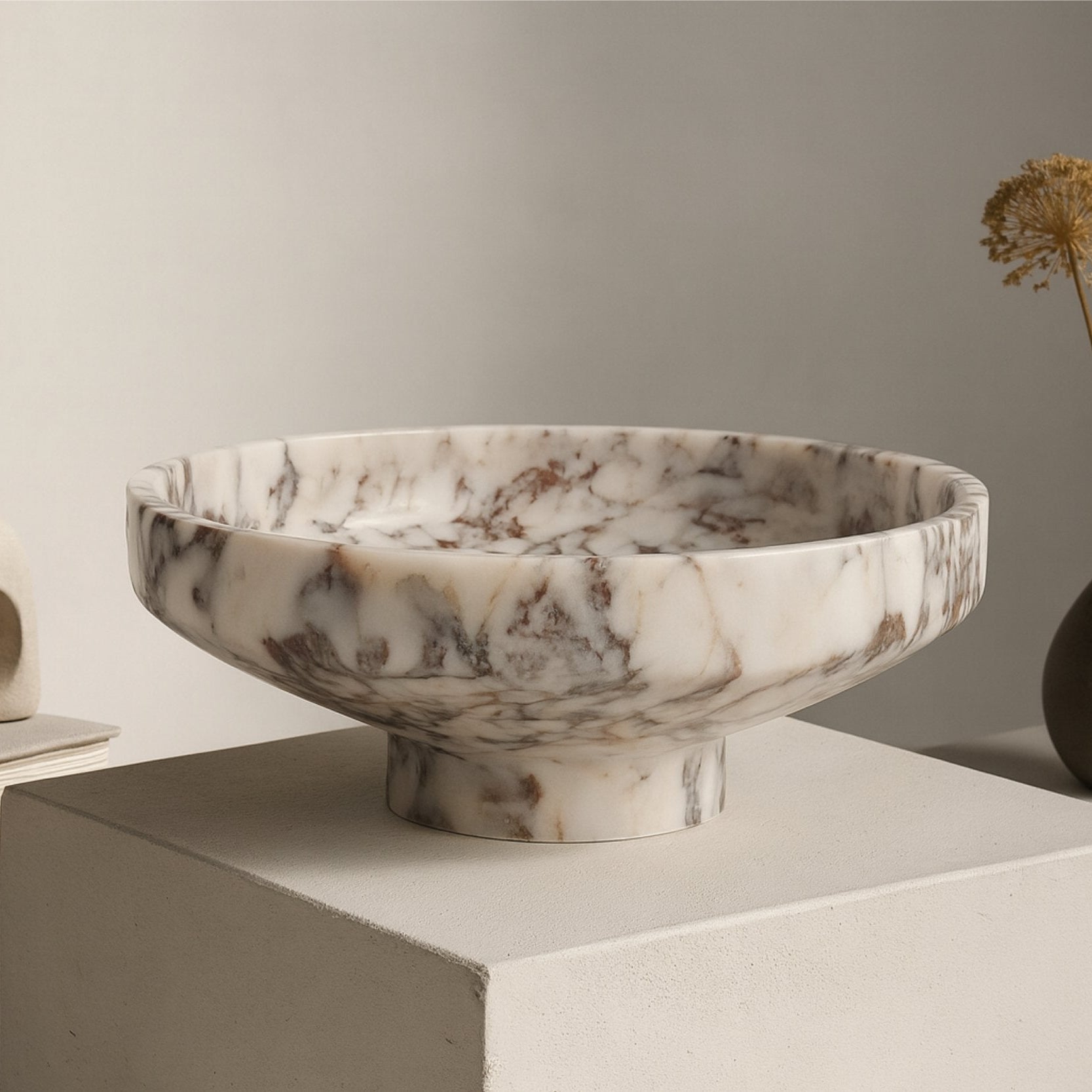 Marble pedestal bowl on wooden table with bread and linen, warm natural morning light scene.