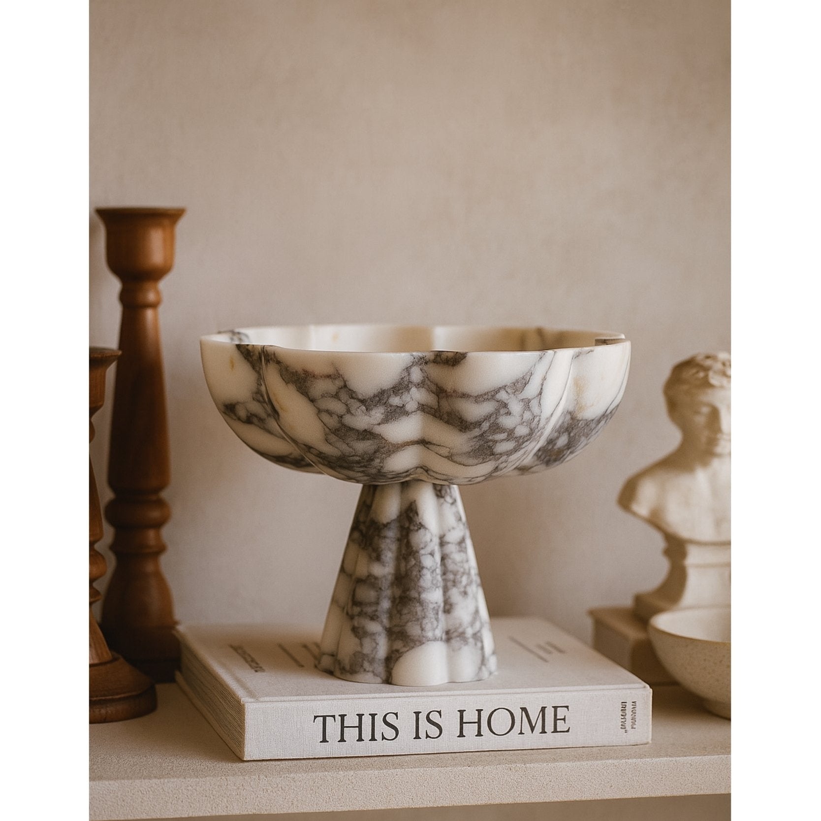Marble pedestal bowl styled on books as living room centerpiece