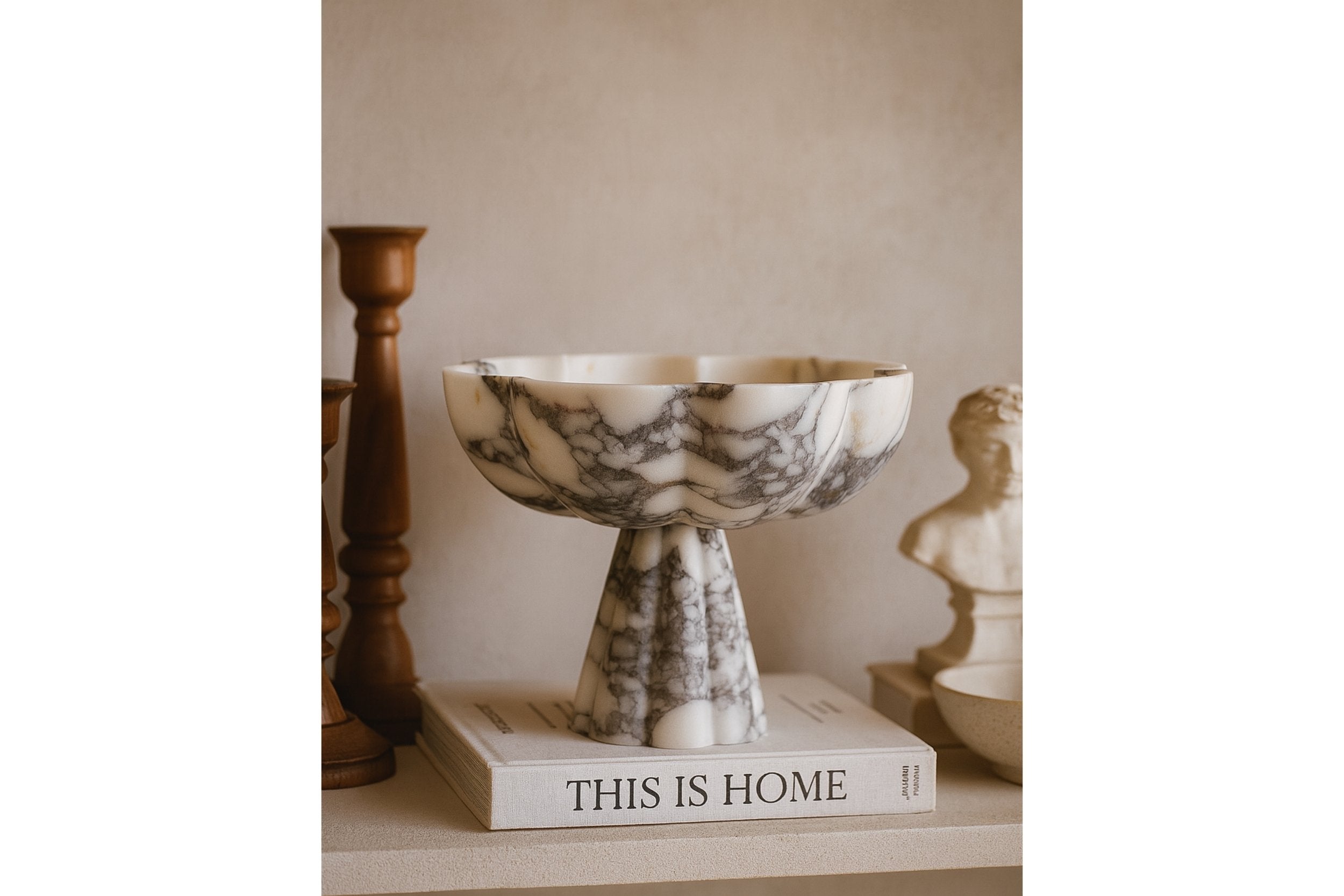 Marble pedestal bowl styled on books as living room centerpiece