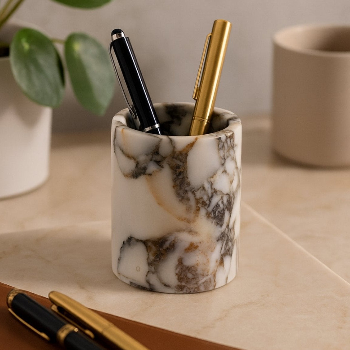 Handcrafted marble pen holder beside books and plants – refined desk organizer with luxurious organic feel.