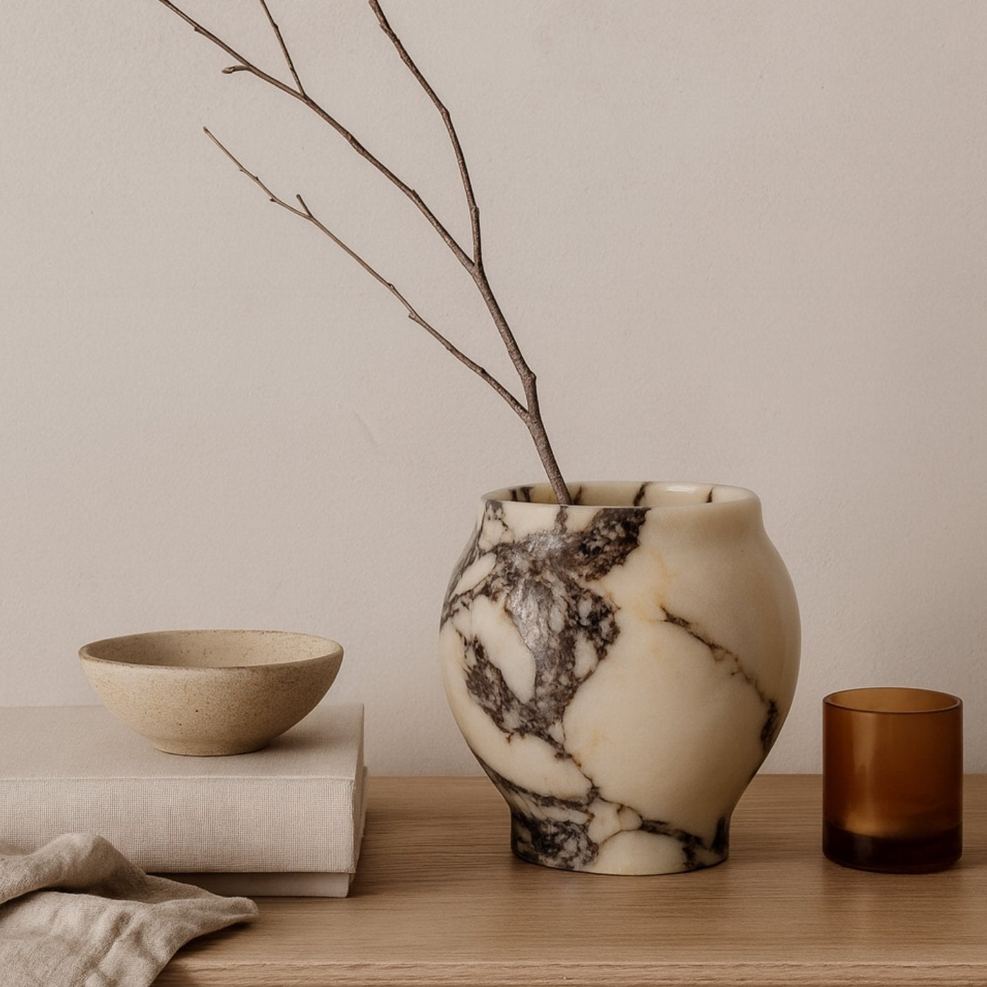 Sculptural marble mortar and pestle on concrete plinth, soft natural light, minimal wabi-sabi aesthetic by Petra Vera.