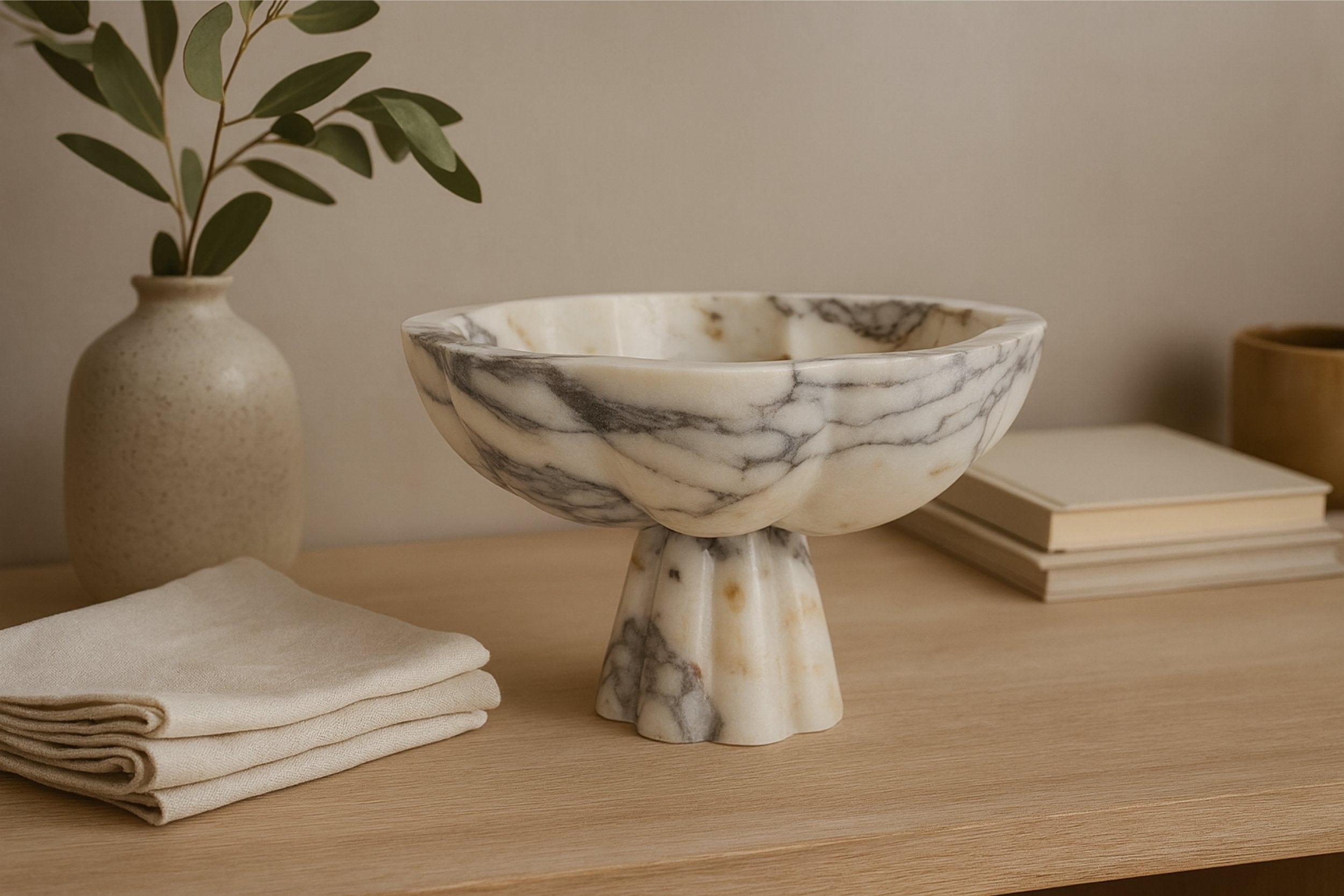 Marble pedestal bowl on wooden surface with natural light — Petra Vera