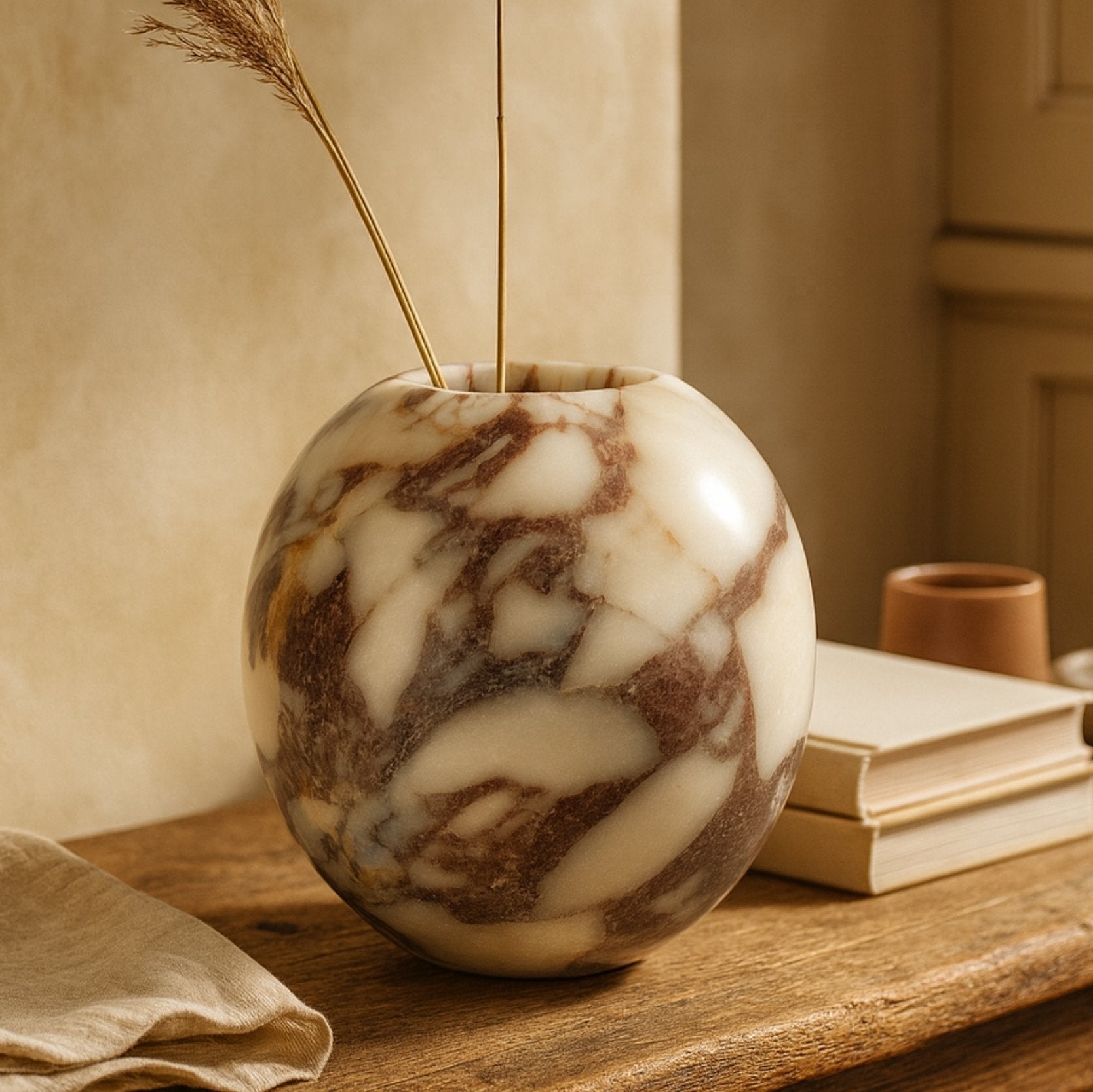 Calacatta Viola marble vase with dried pampas decor on a rustic wooden table, warm ambient tones, luxury handcrafted homeware.