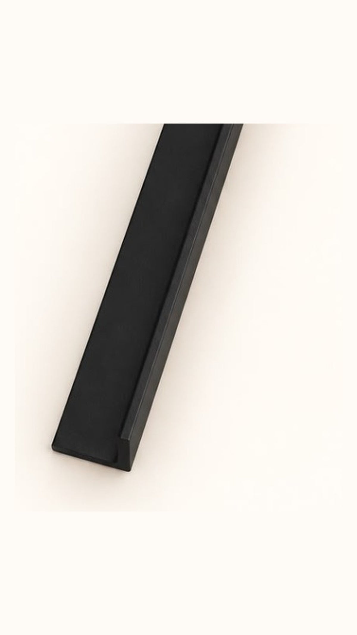 Close-up of a black metal support arm tip, showing the flat surface and single raised edge of its L-shaped cross-section.