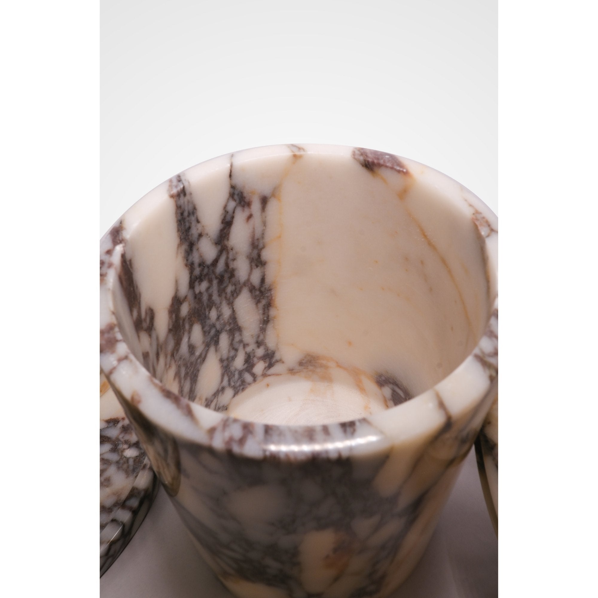 “Top view of Calacatta Viola marble bathroom accessories set on round marble tray”