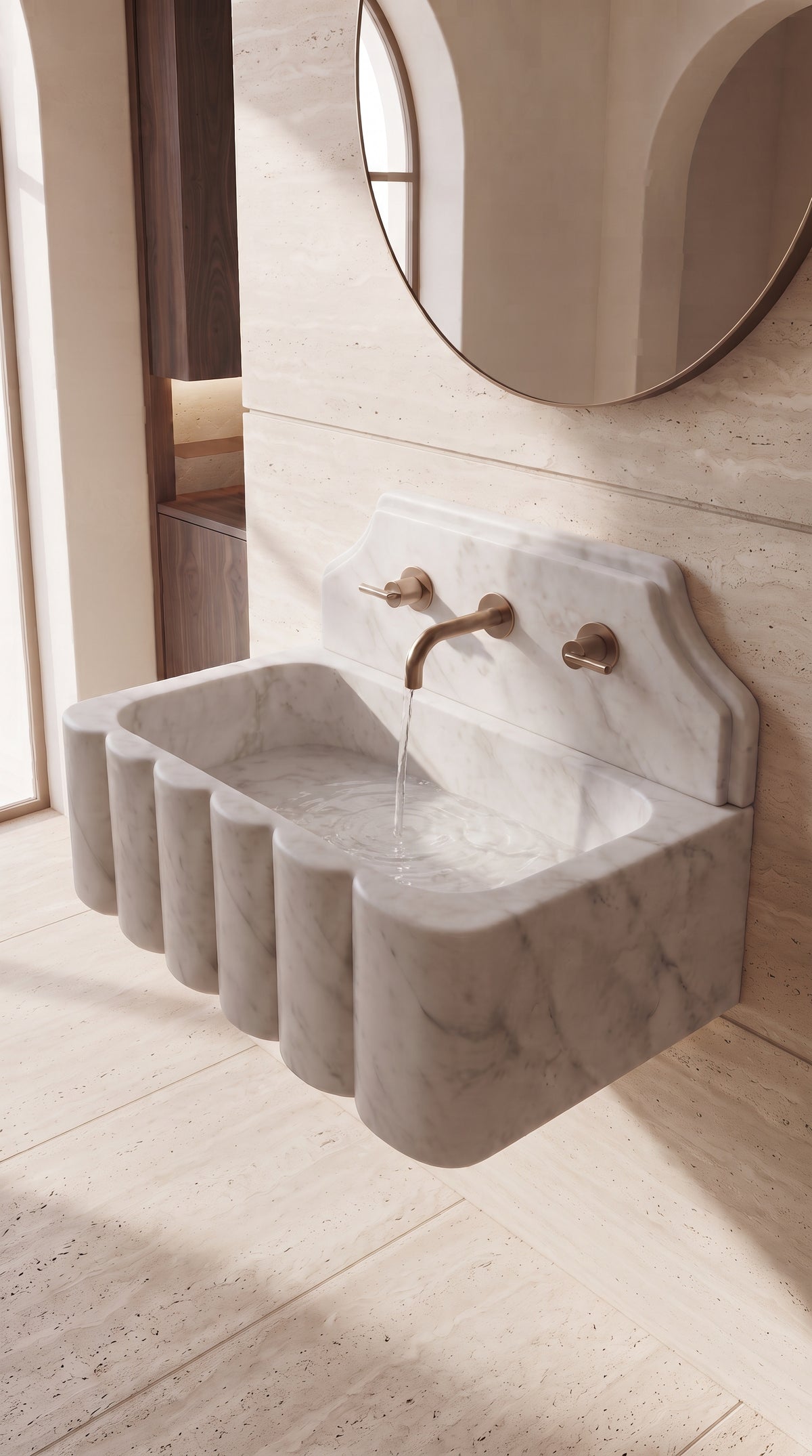 Clear water flowing from a brass faucet into a handcrafted Muğla White marble sink with a sculptural scalloped front.