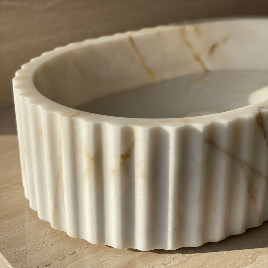 Close-up detail of fluted marble sink texture highlighting handcrafted grooves and natural stone veining
