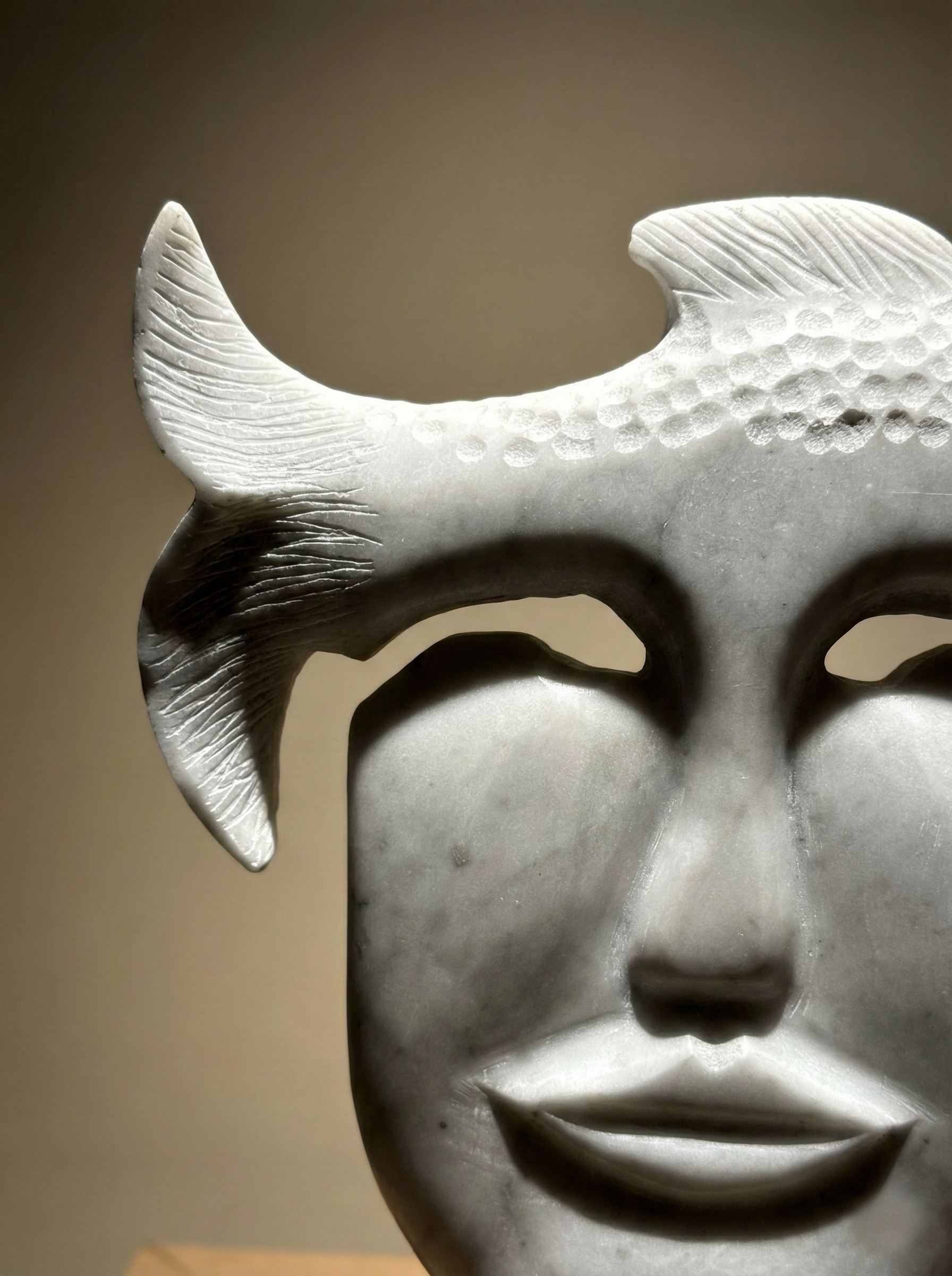 close up marble face sculpture with fish minimalist art object
