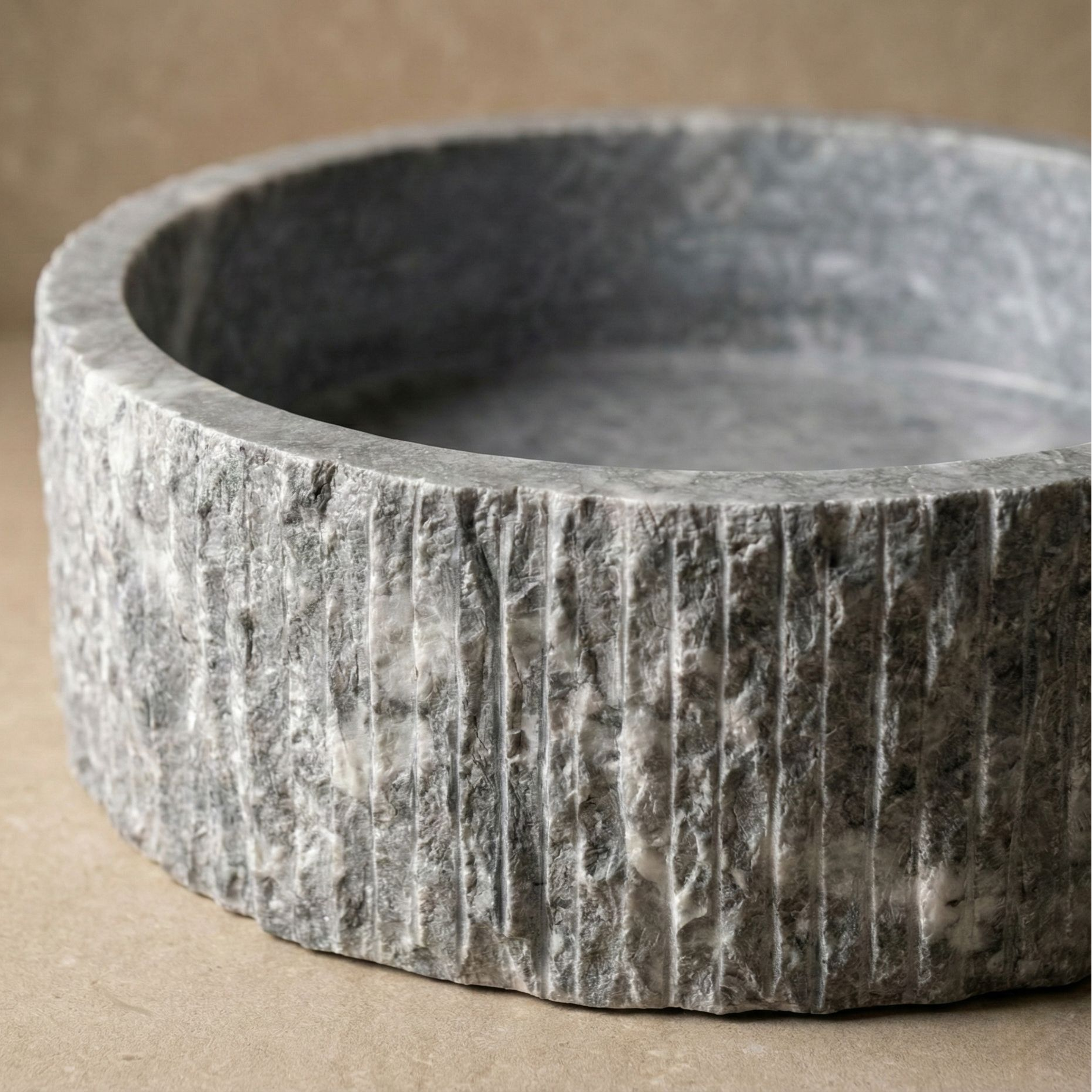 Close up texture of hand carved fluted dark grey marble vessel sink