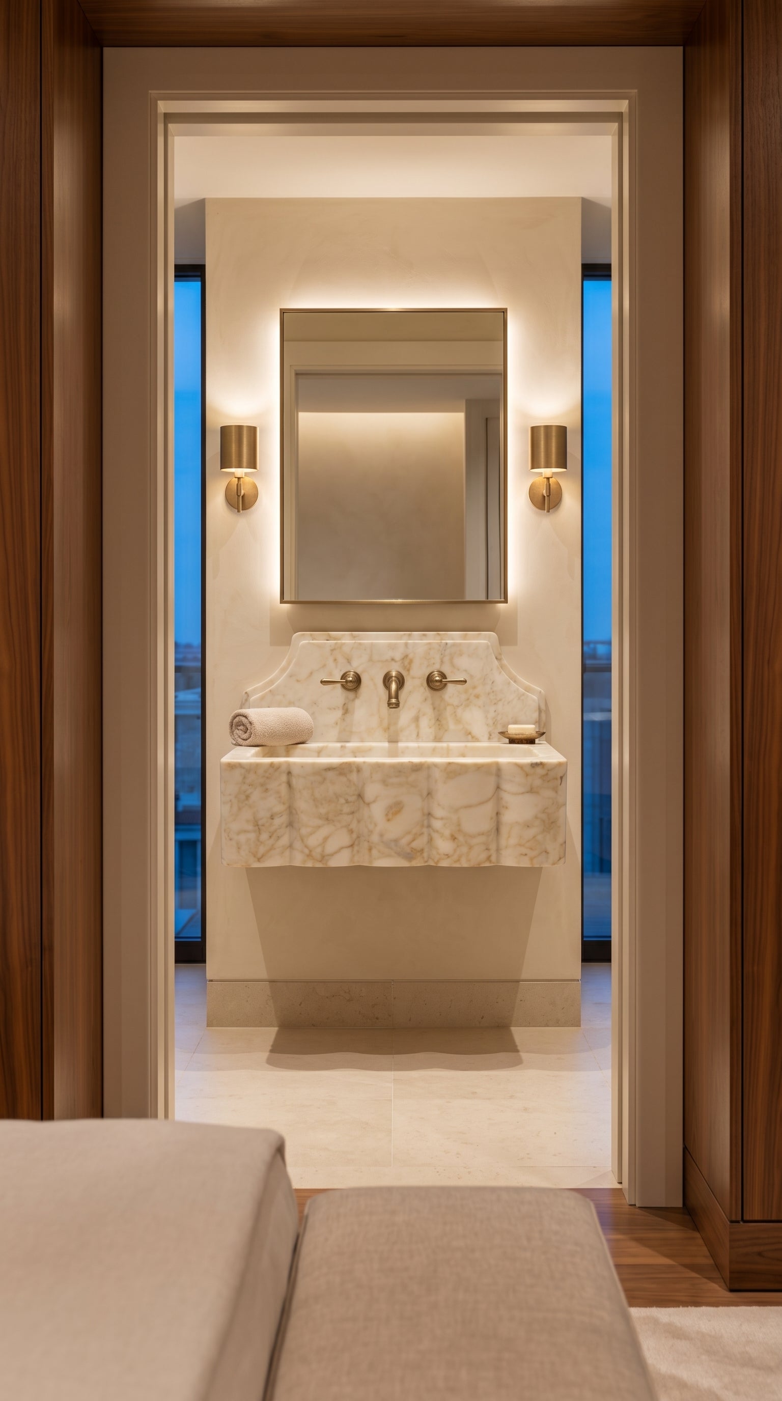 Calacatta Gold marble sink viewed through a luxury hotel suite doorway, featuring a floating installation and elegant bathroom styling.