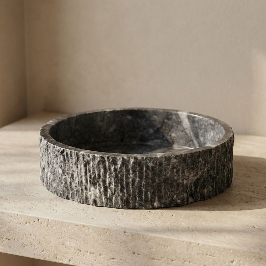 Dark grey marble round vessel sink with hand carved fluted exterior by Petra Vera