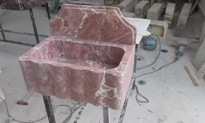 Red travertine wall mounted sink showcasing natural stone texture and handcrafted details.