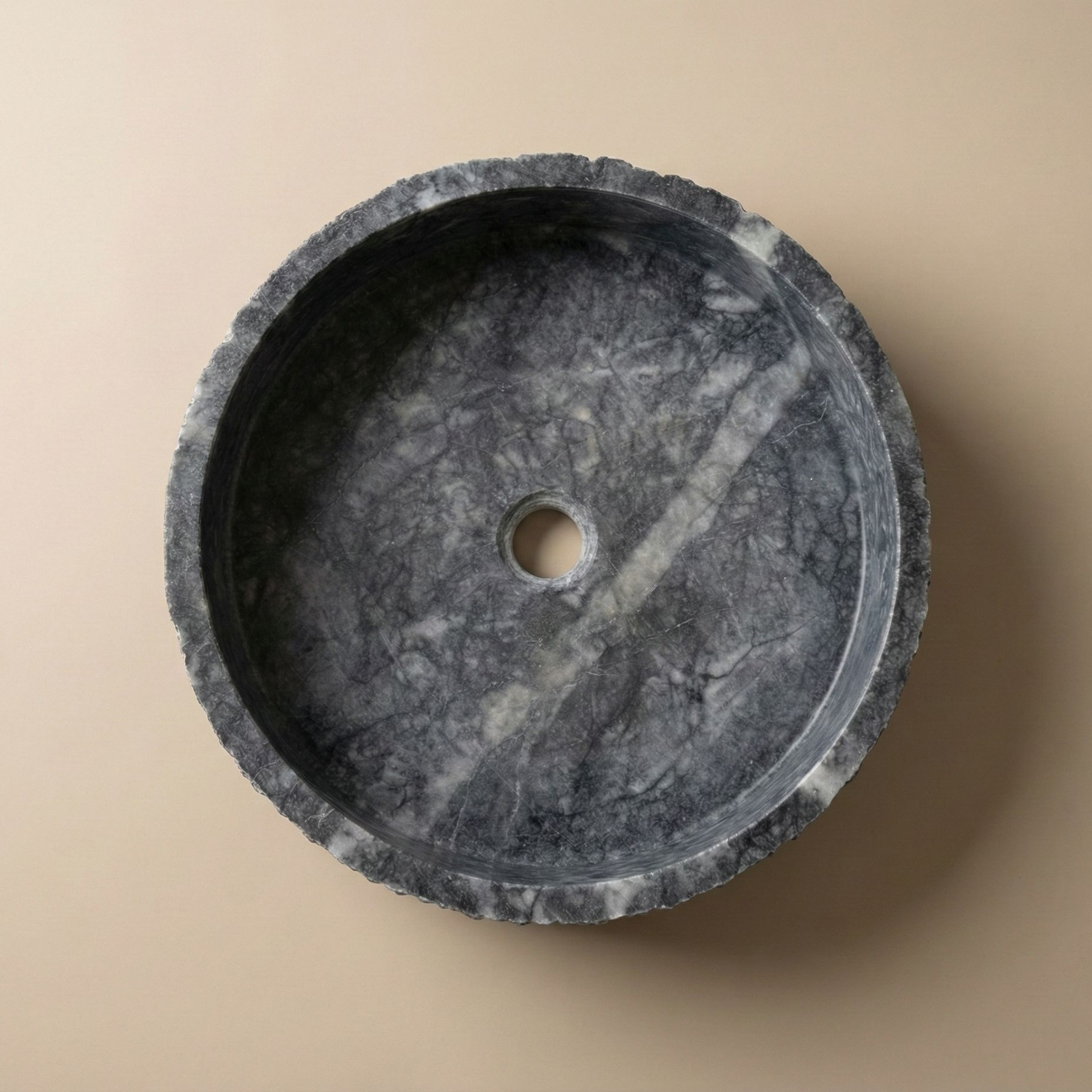 Top view of dark grey marble round vessel sink with natural stone veining