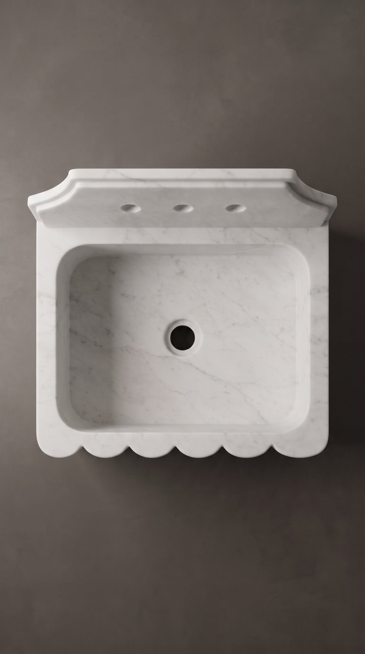 Overhead view of a Muğla White marble sink with rectangular basin, rounded corners, central drain opening and scalloped front edge.